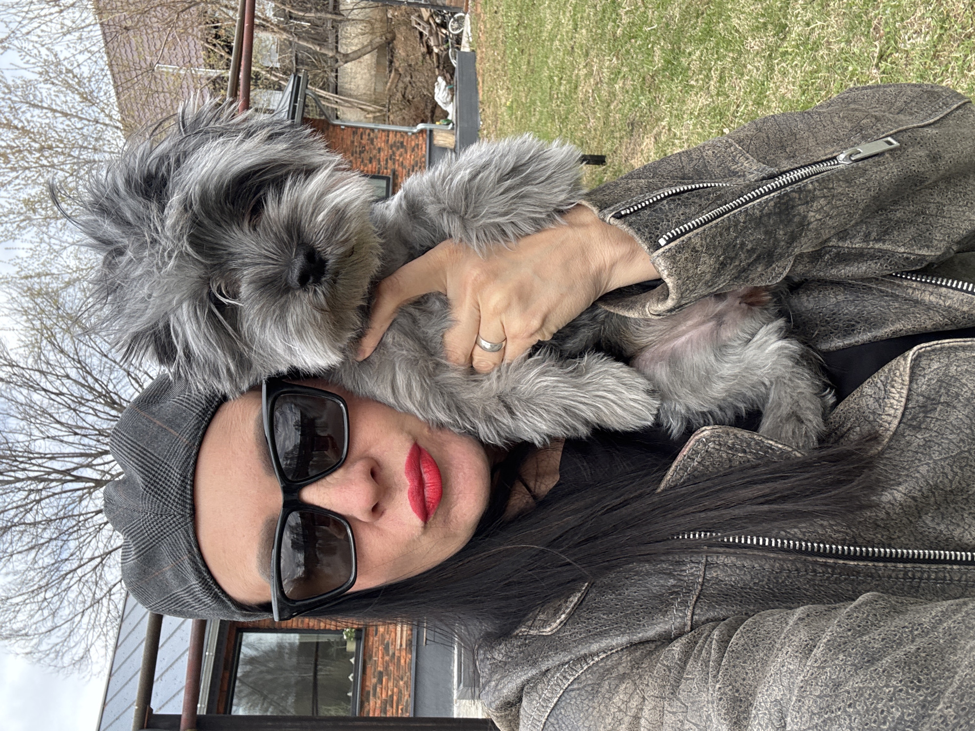 Woman with small grey dog photographed outdoors in Chaikovsky