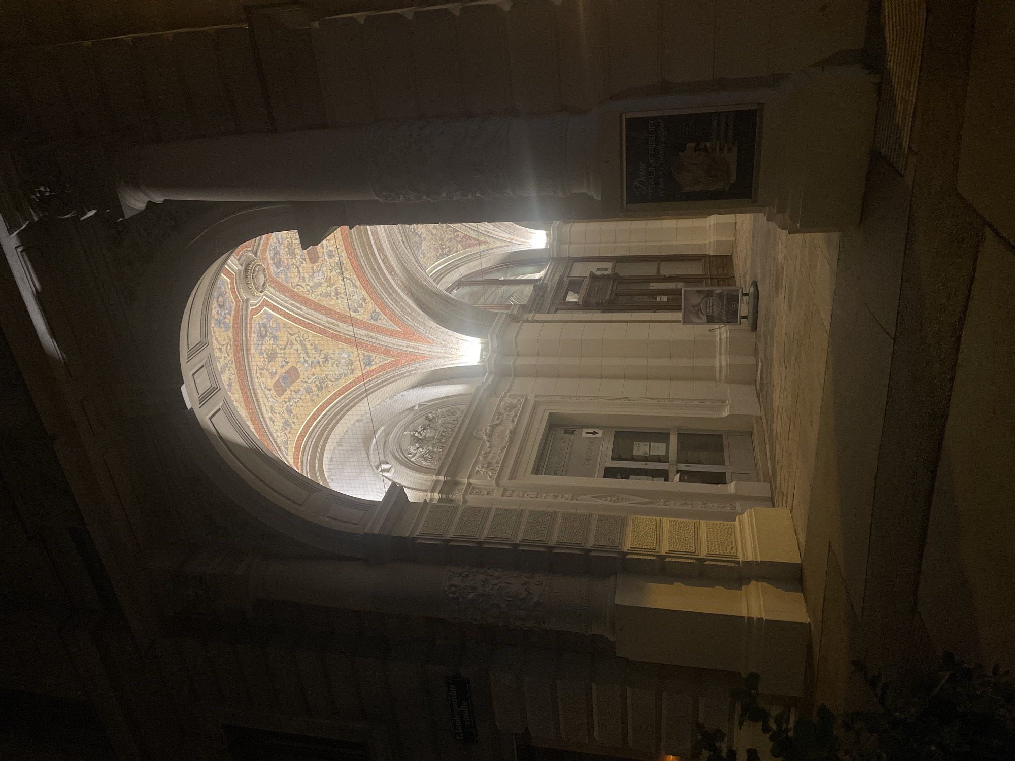 Woman enjoys evening drink near ornate Vienna archway