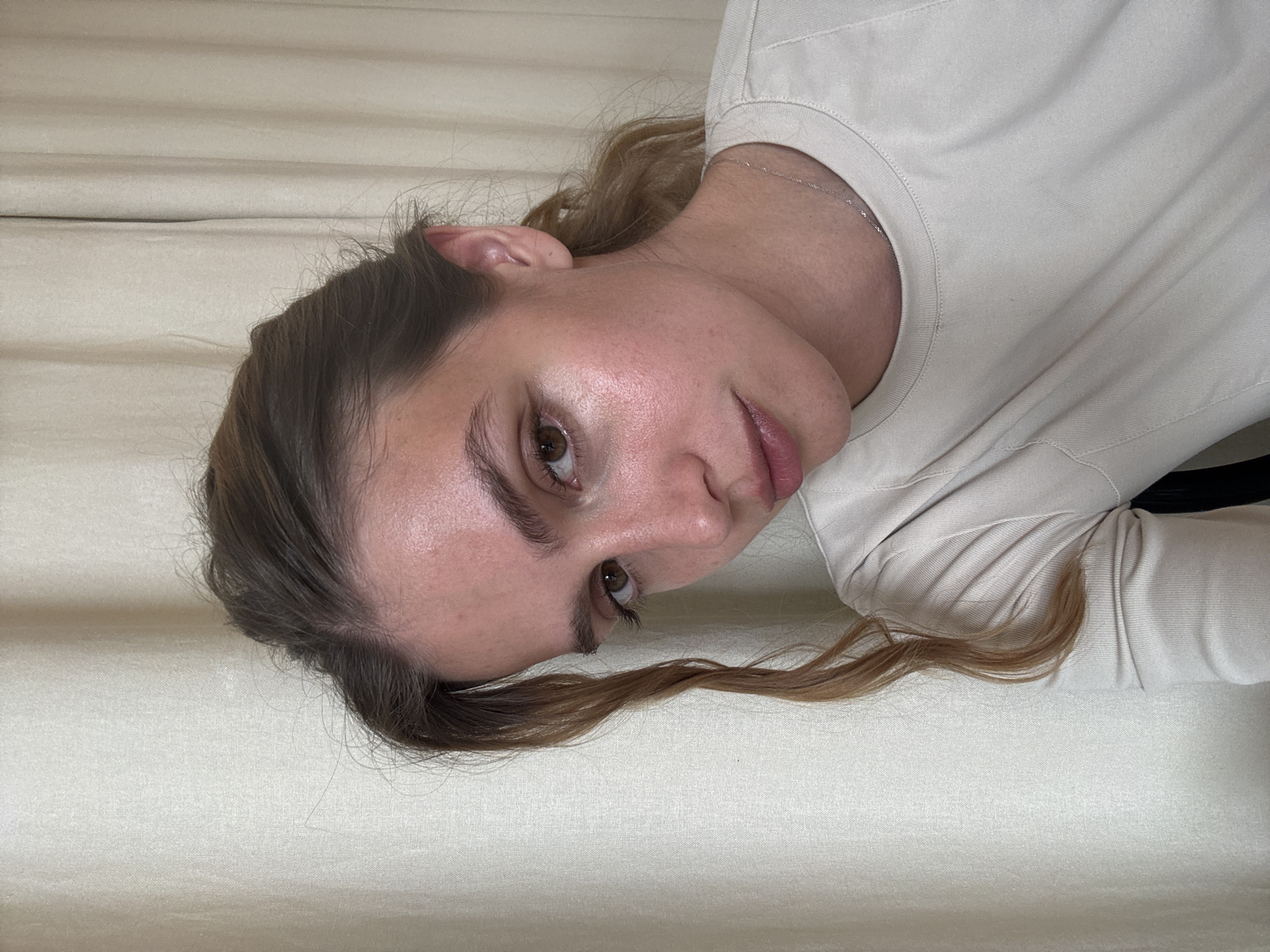 Woman in beige shirt observed in close-up portrait