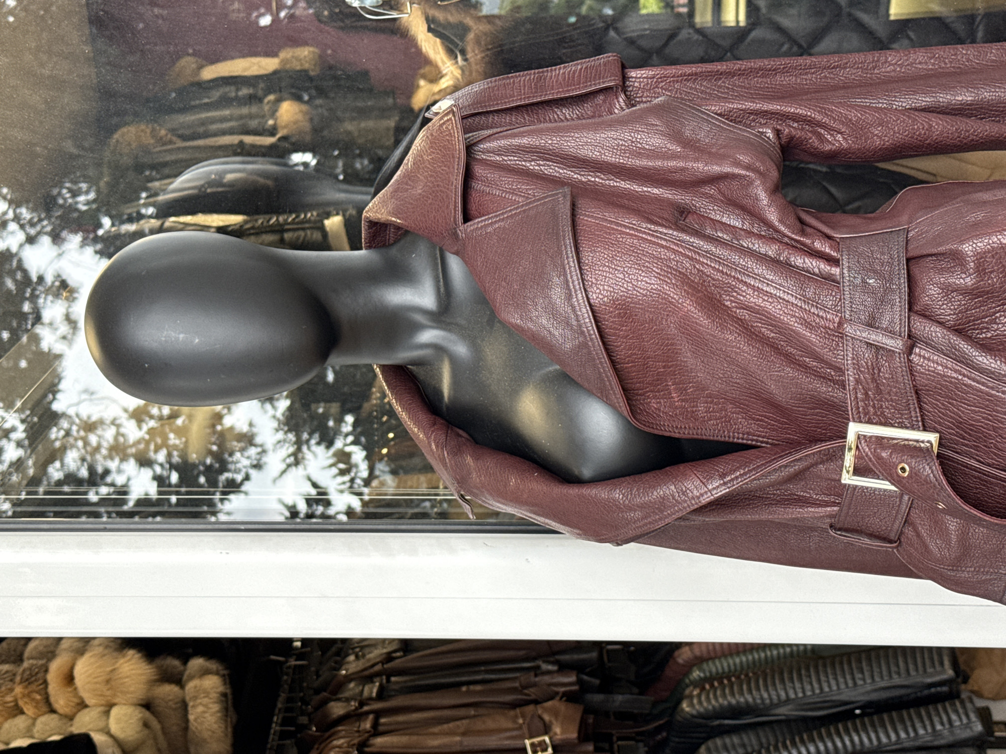 Store window display features burgundy leather garment in Montenegro