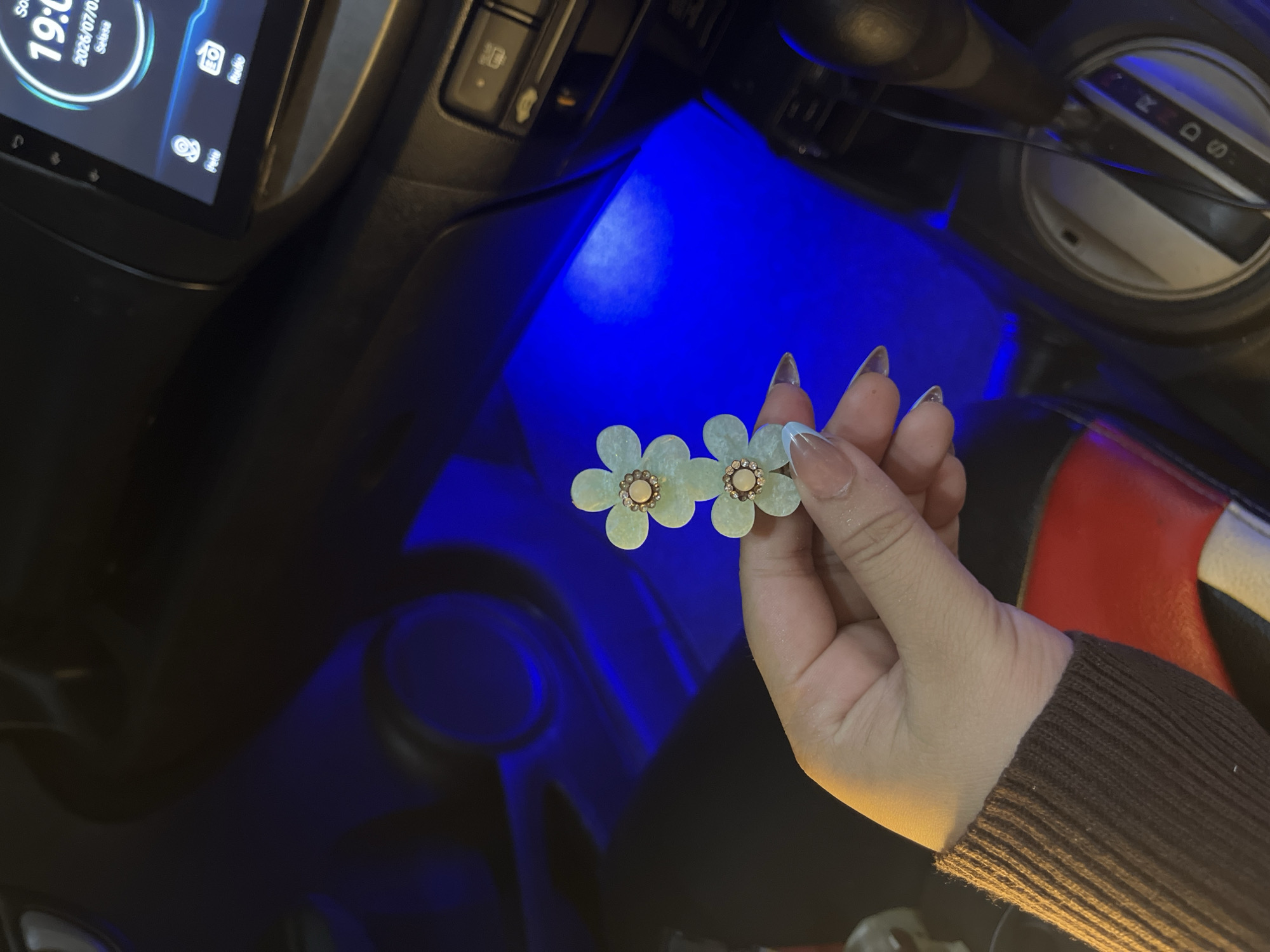 Beauty products previewed inside a blue-lit car in Indonesia