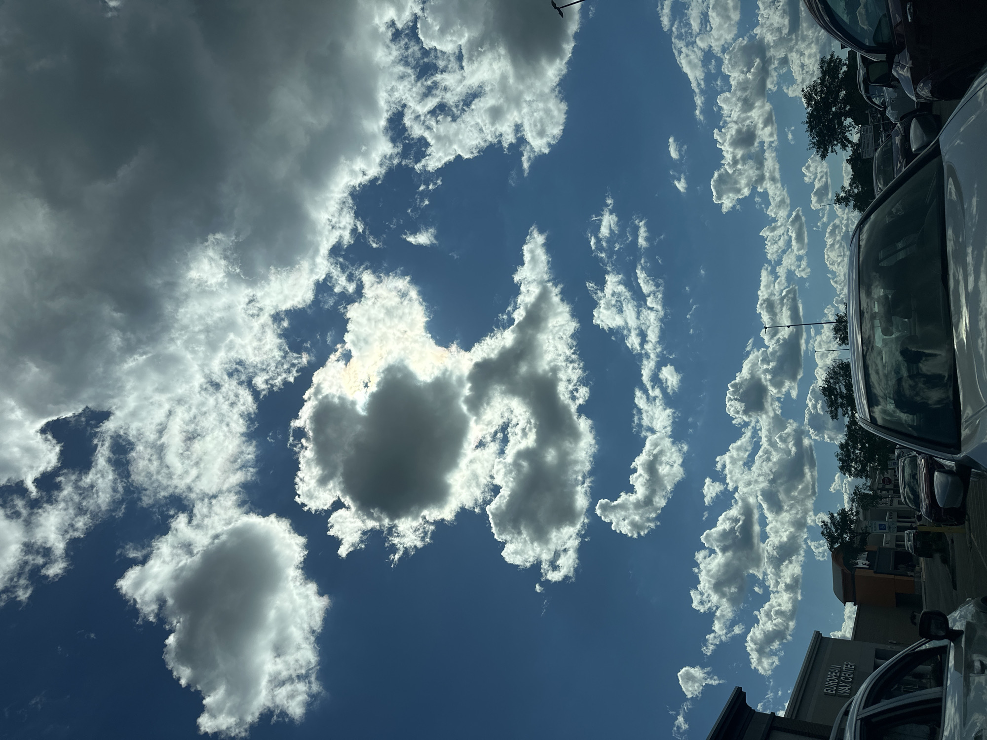 Summer sky over a Rockford parking lot, clouds and sun