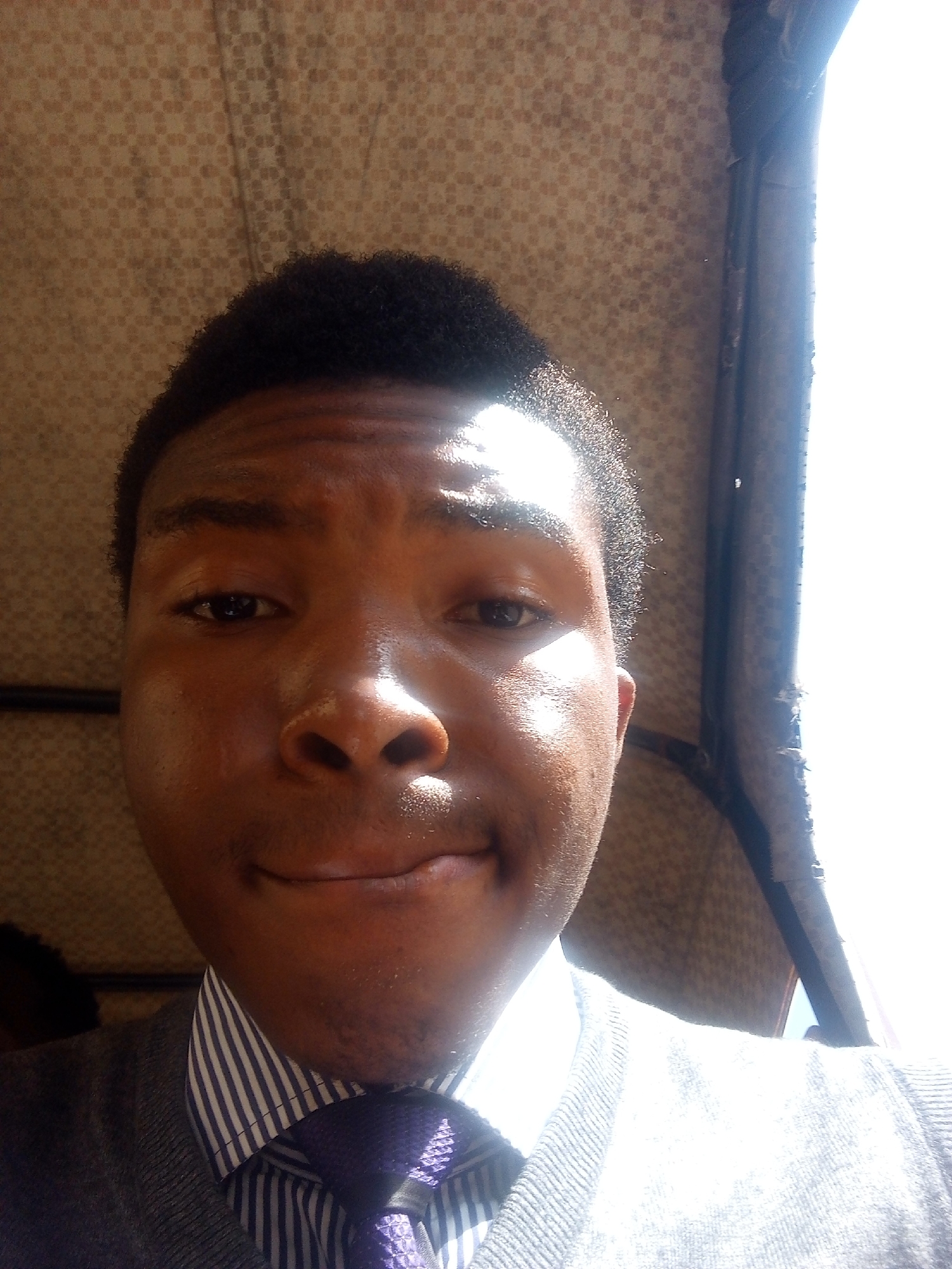 Young man in formal wear documented with green folder in Jos
