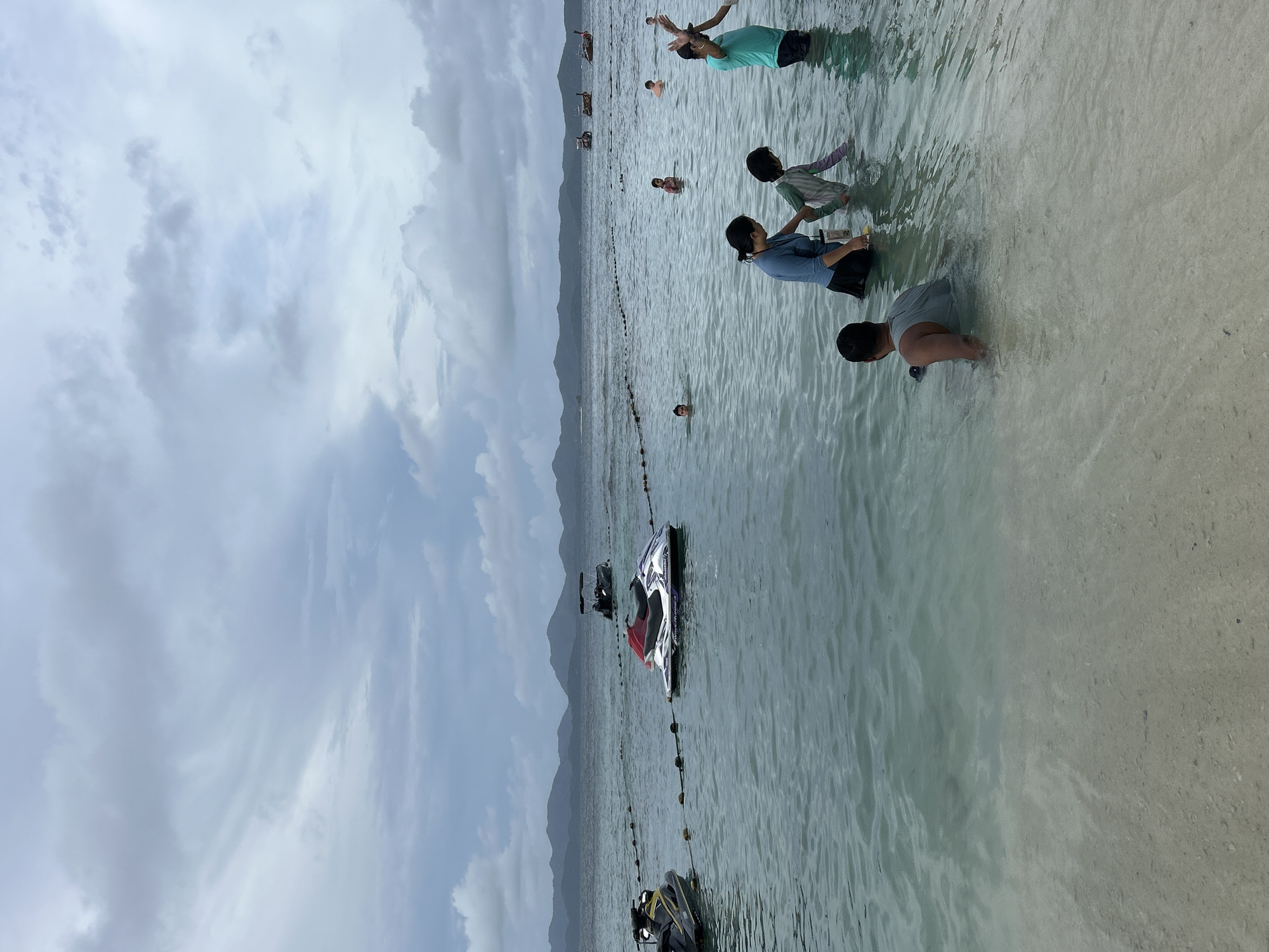 Crowded beach morning in Phru Nai with jet skis and families