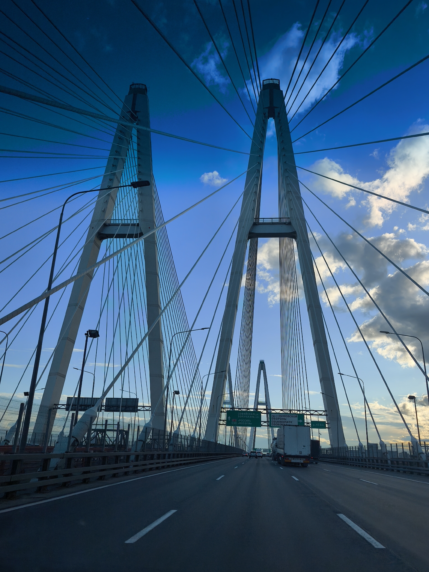 Vehicle crosses cable-stayed bridge on clear afternoon