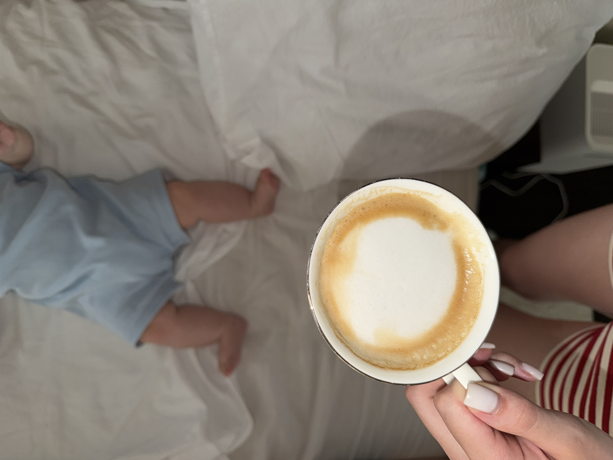 Early morning moment: baby rests as adult enjoys coffee