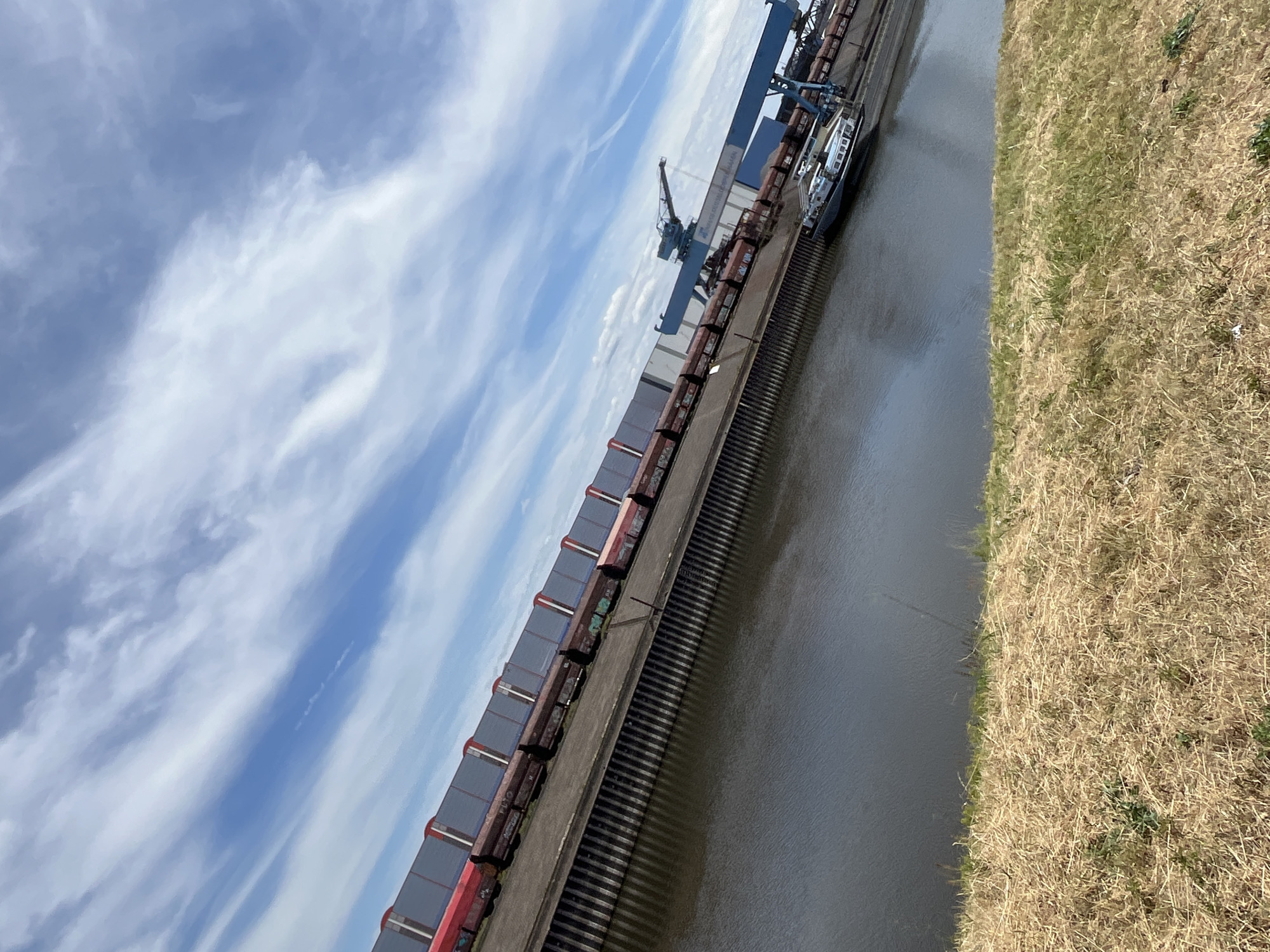Freight train docked at Neuss industrial port alongside a canal