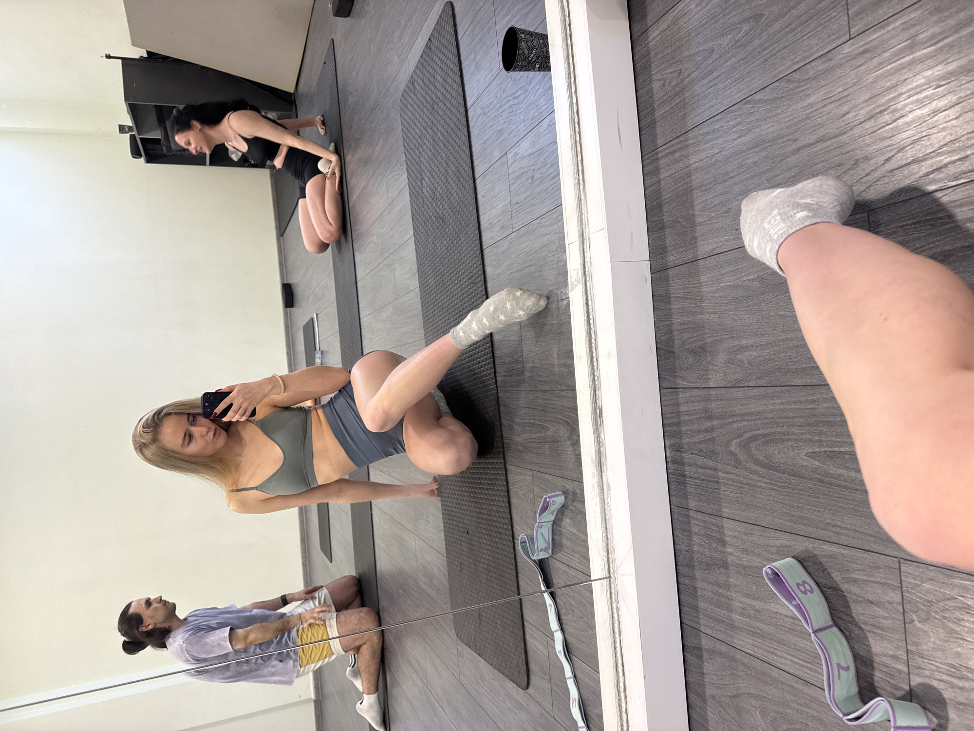 Yoga class participants practice poses, document session with selfies