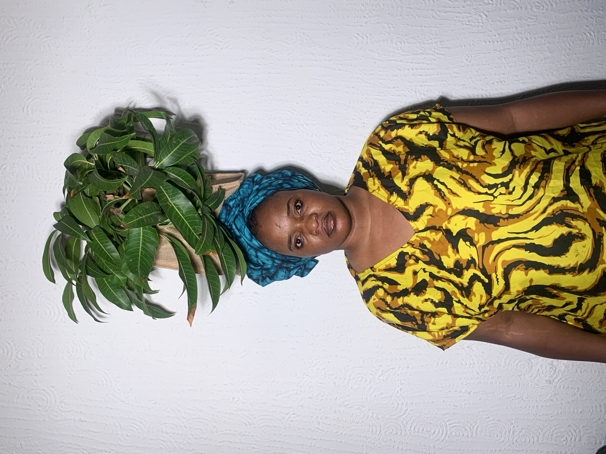 Woman with mango leaves photographed in Nigerian home portrait session