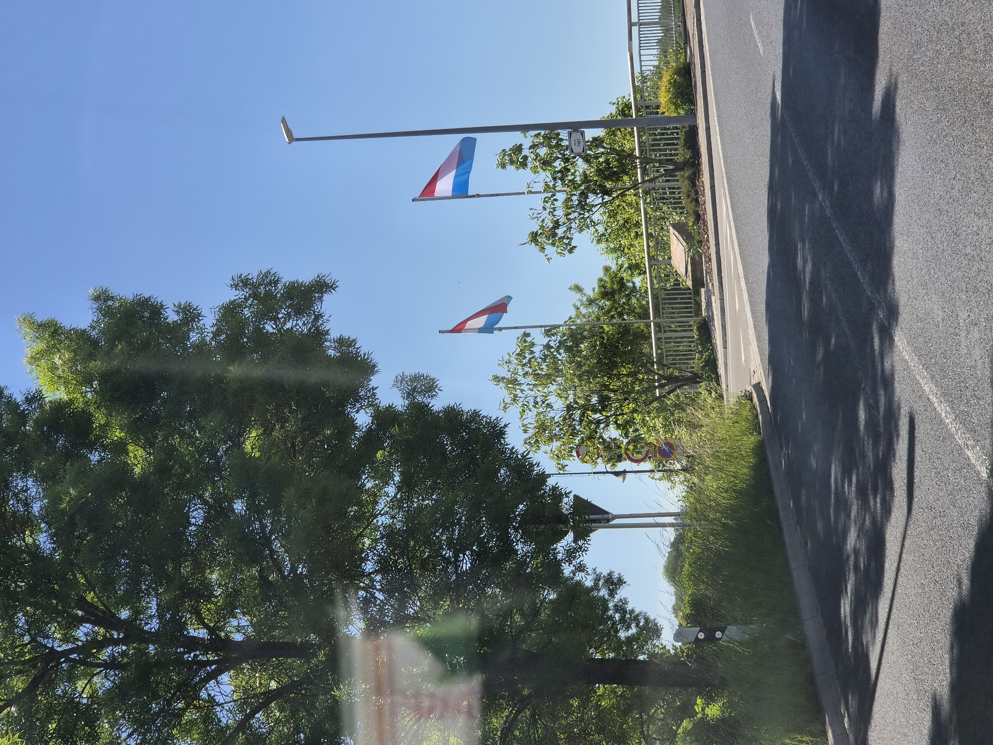 Luxembourg flags displayed along roadside in Oetrange