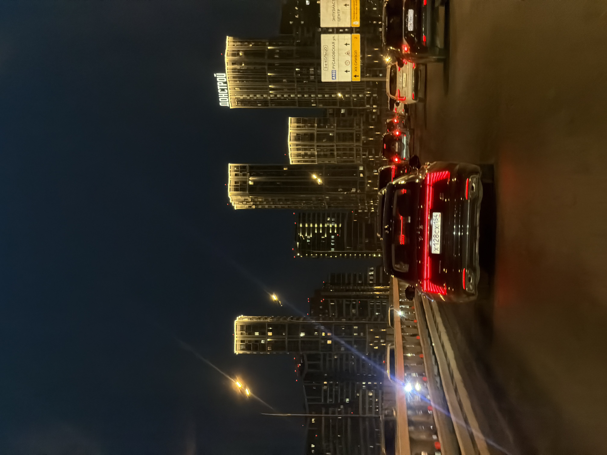 Nighttime traffic captured on Moscow highway amid illuminated skyline
