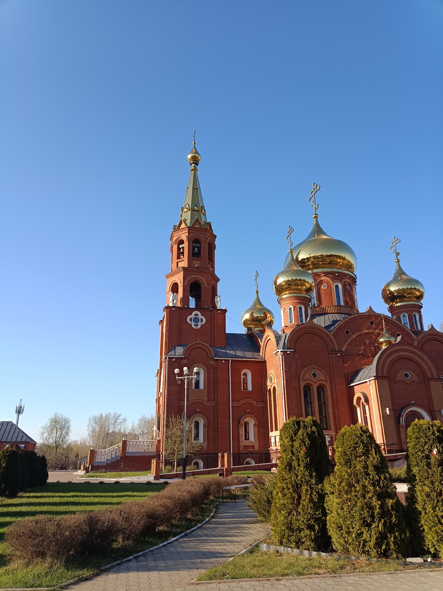 Red brick Russian Orthodox church with golden domes observed