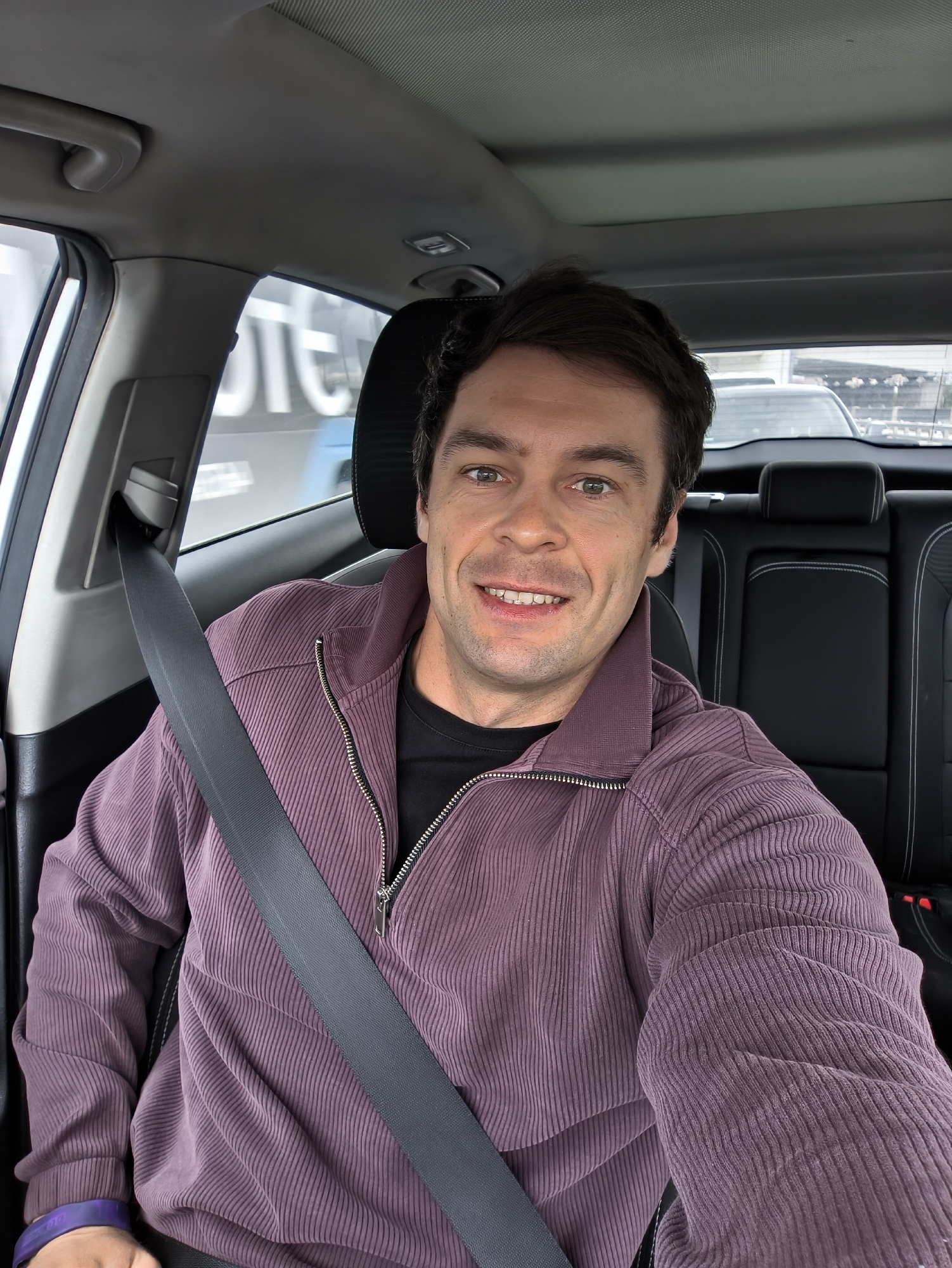 Man takes smiling selfie in car in Moscow