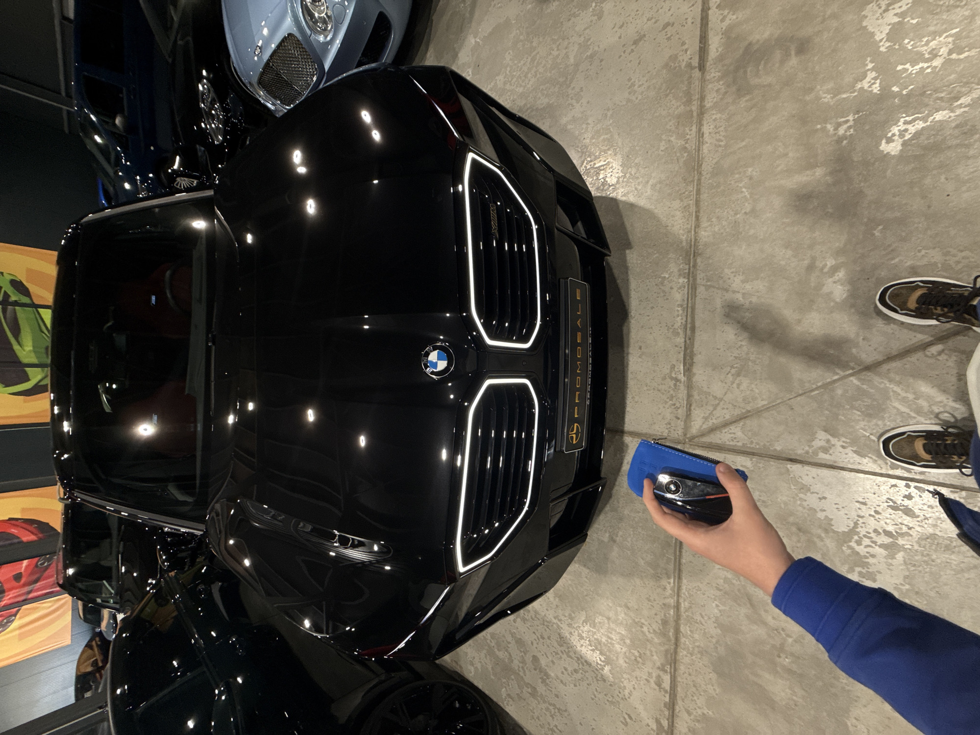 Person with car key approaches BMW in Plovdiv garage