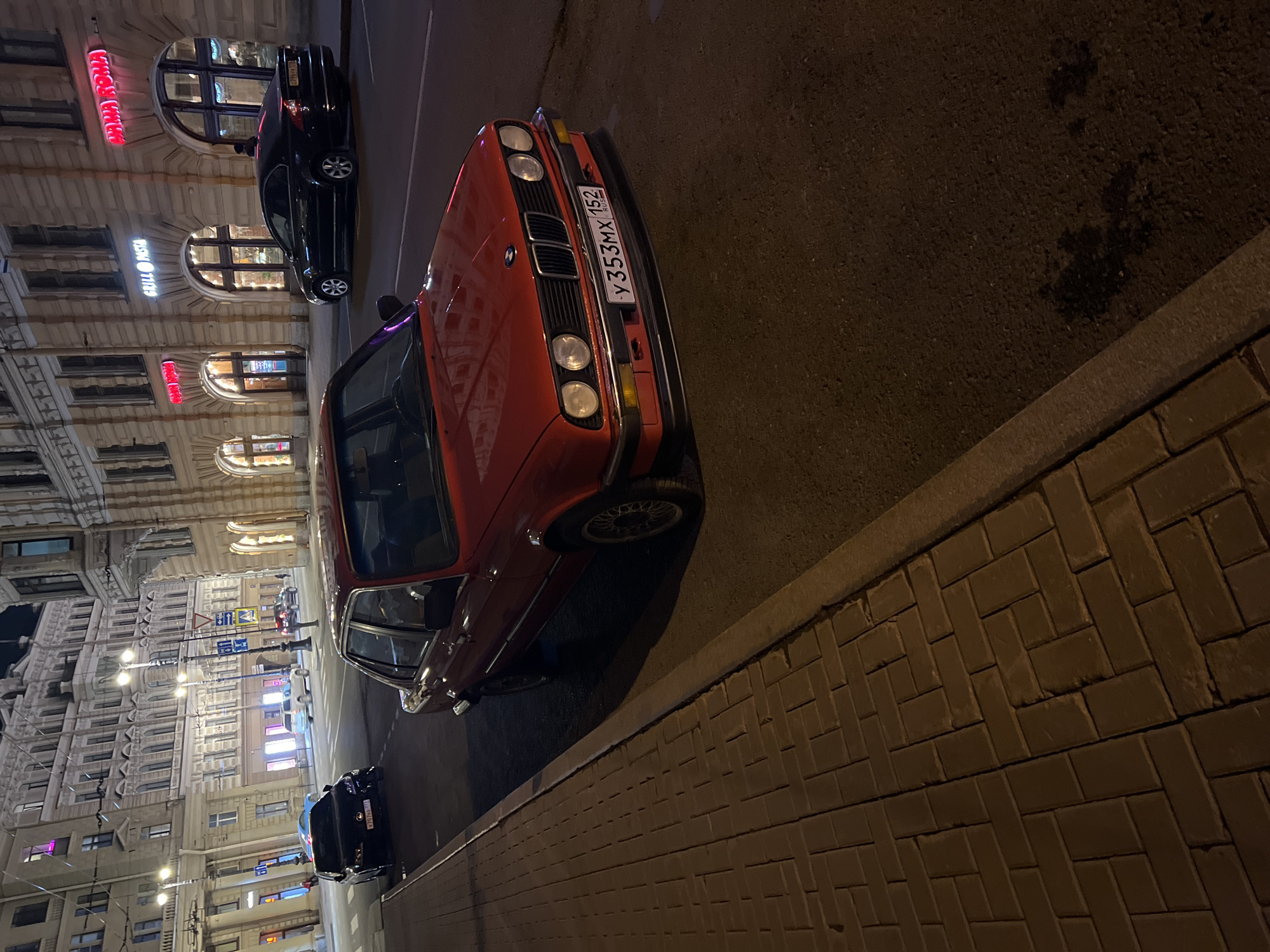 Pedestrians cross nighttime street in Saint Petersburg