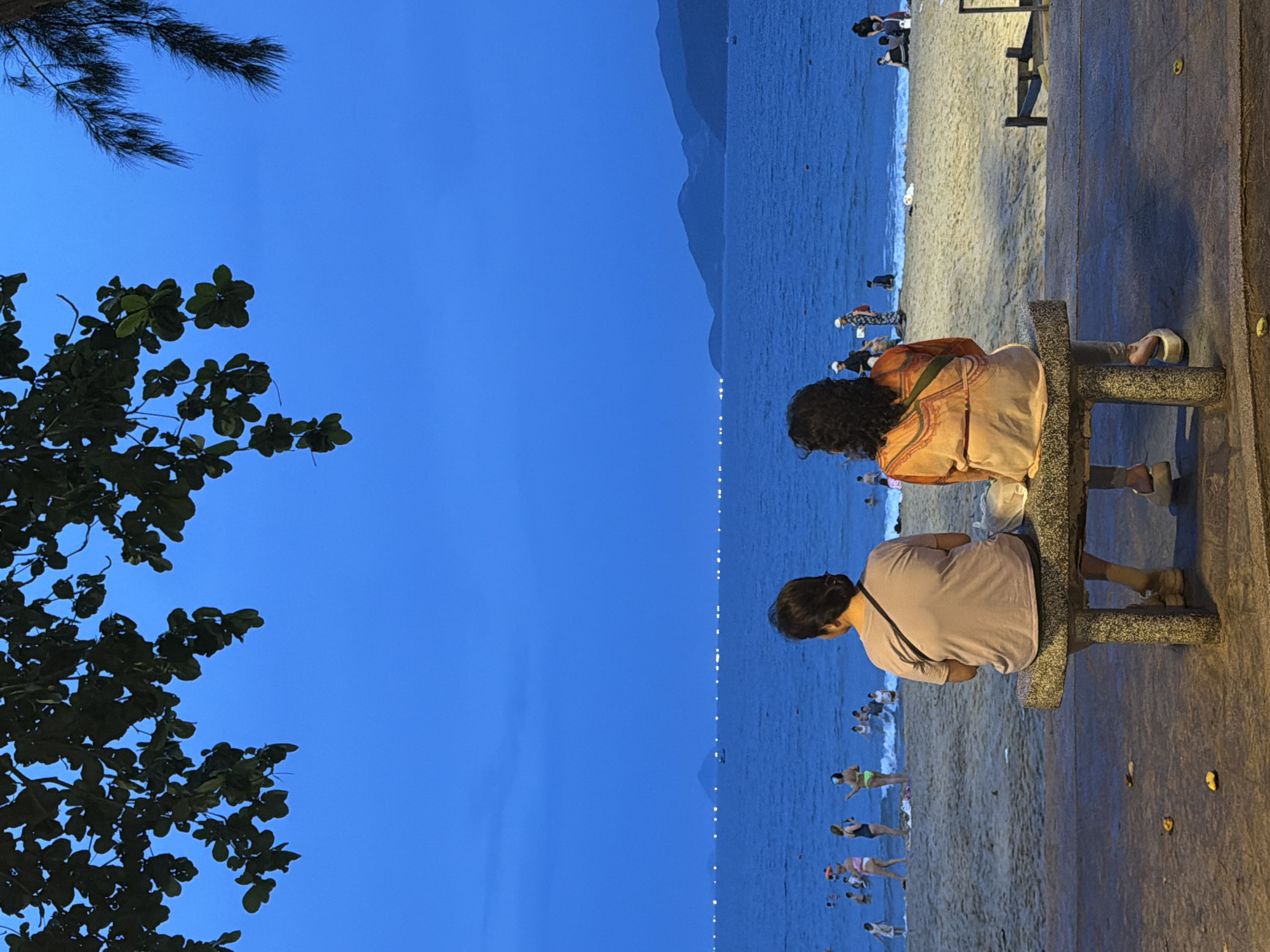 Nha Trang beachfront at dusk, people watching the ocean