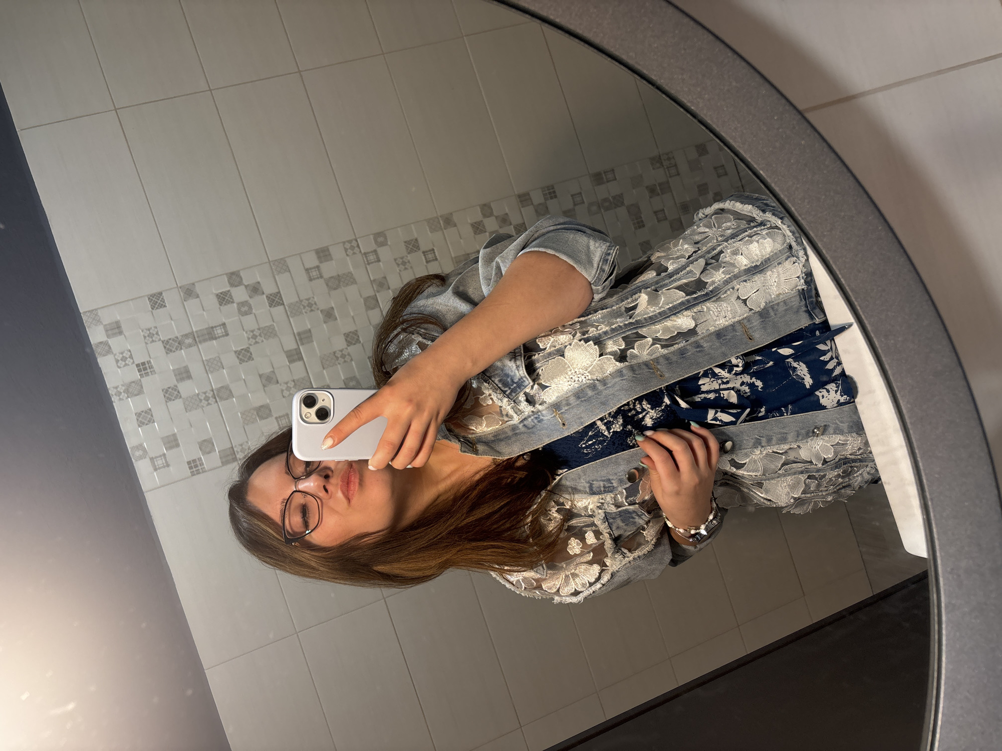 Bathroom mirror selfie in floral dress and denim jacket