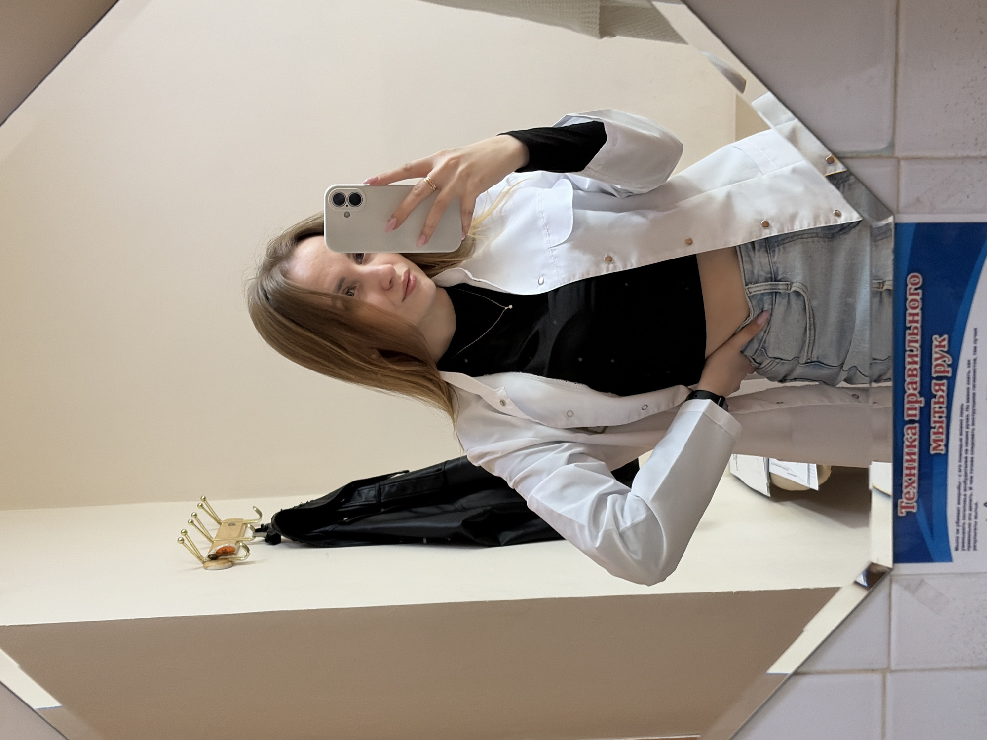 Woman in lab coat takes mirror selfie in Chaikovsky