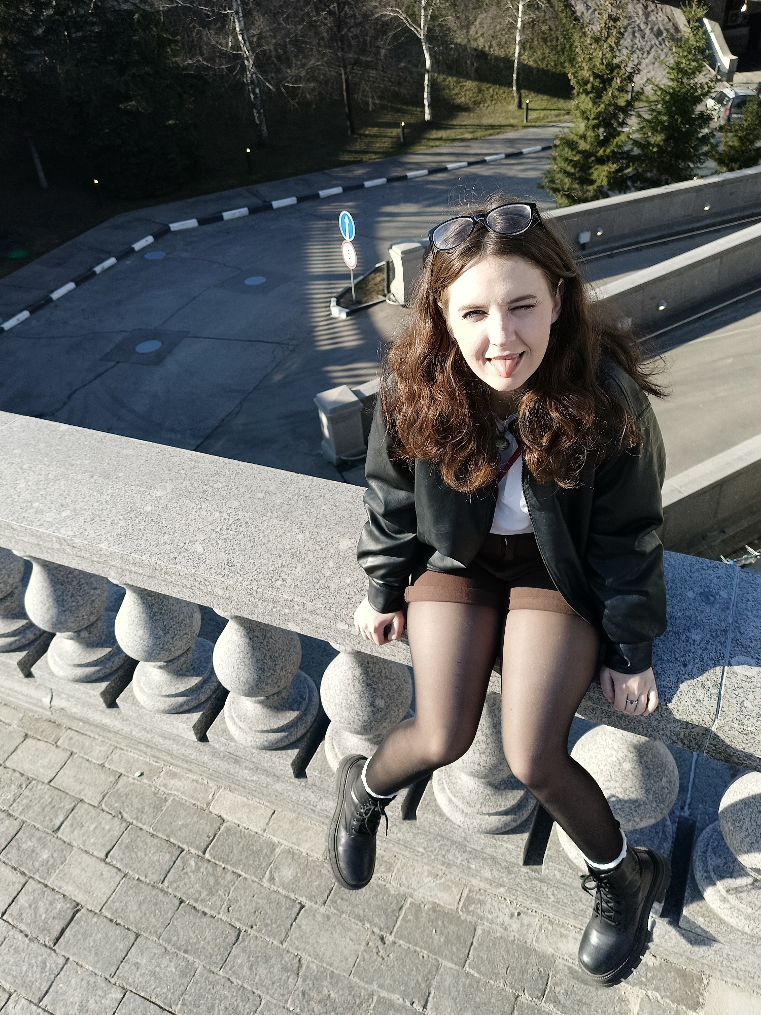 Woman poses playfully on stone balustrade in Moscow