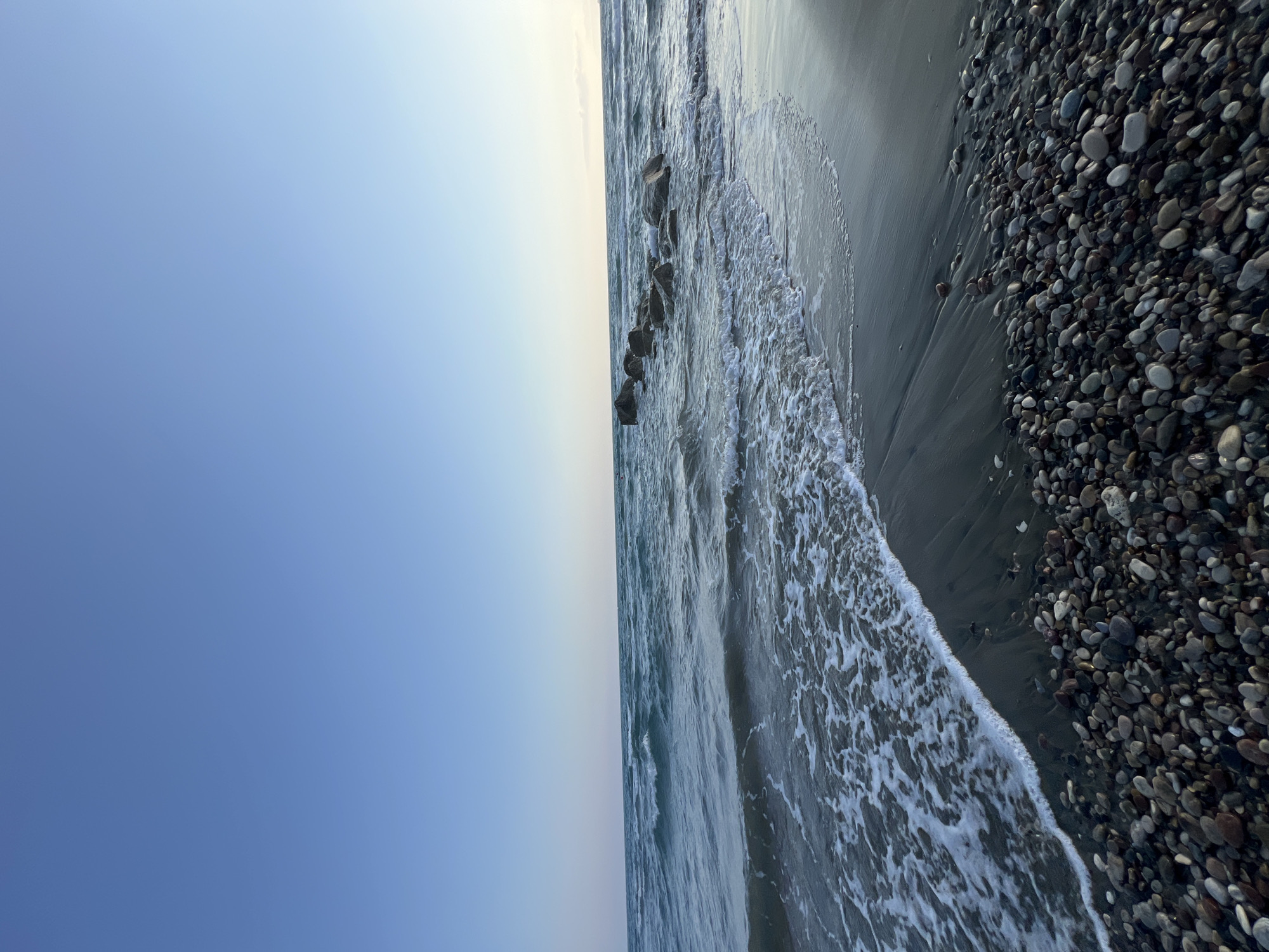 Close-up views of Episkopi's pebble beach on a calm afternoon