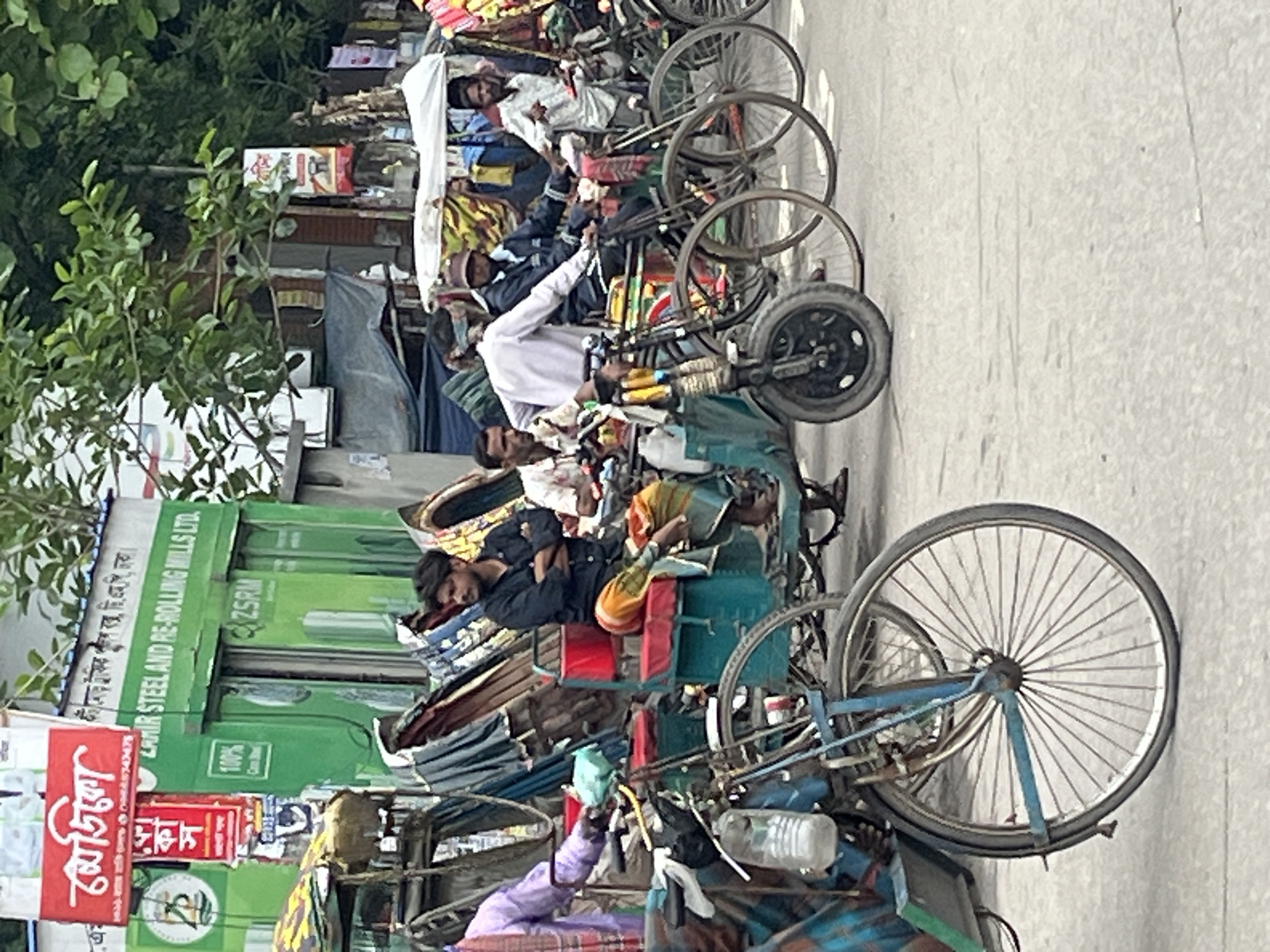Rickshaw pullers gather on busy Dhaka street