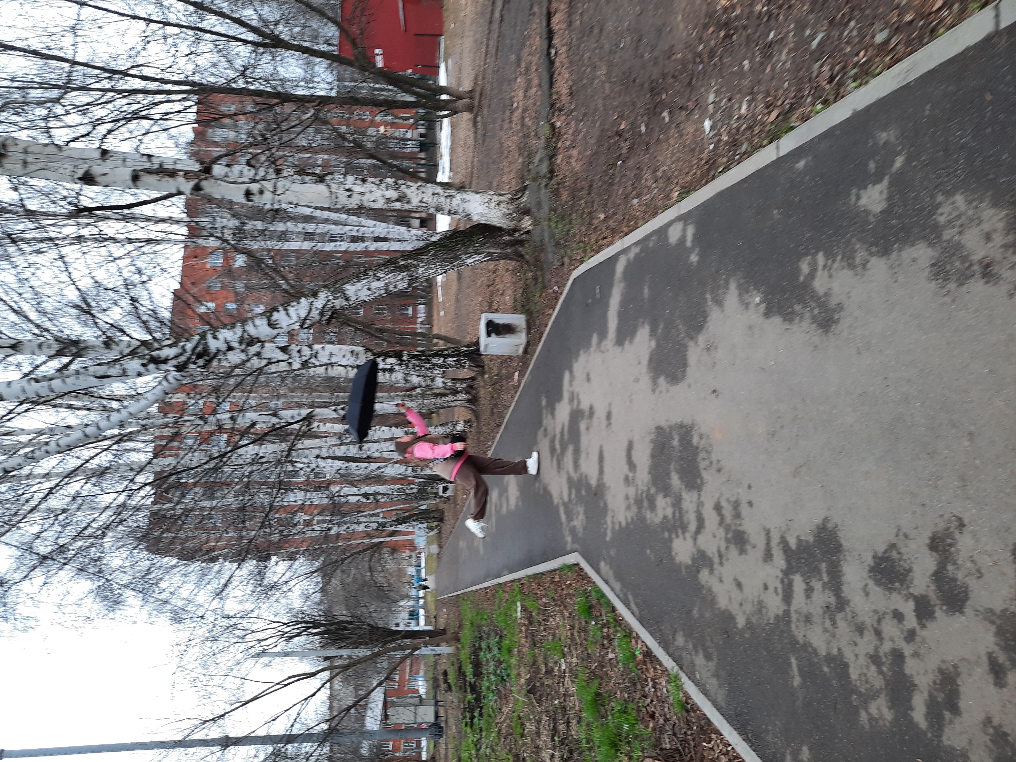 Pedestrians navigate wet sidewalks in Izhevsk during afternoon