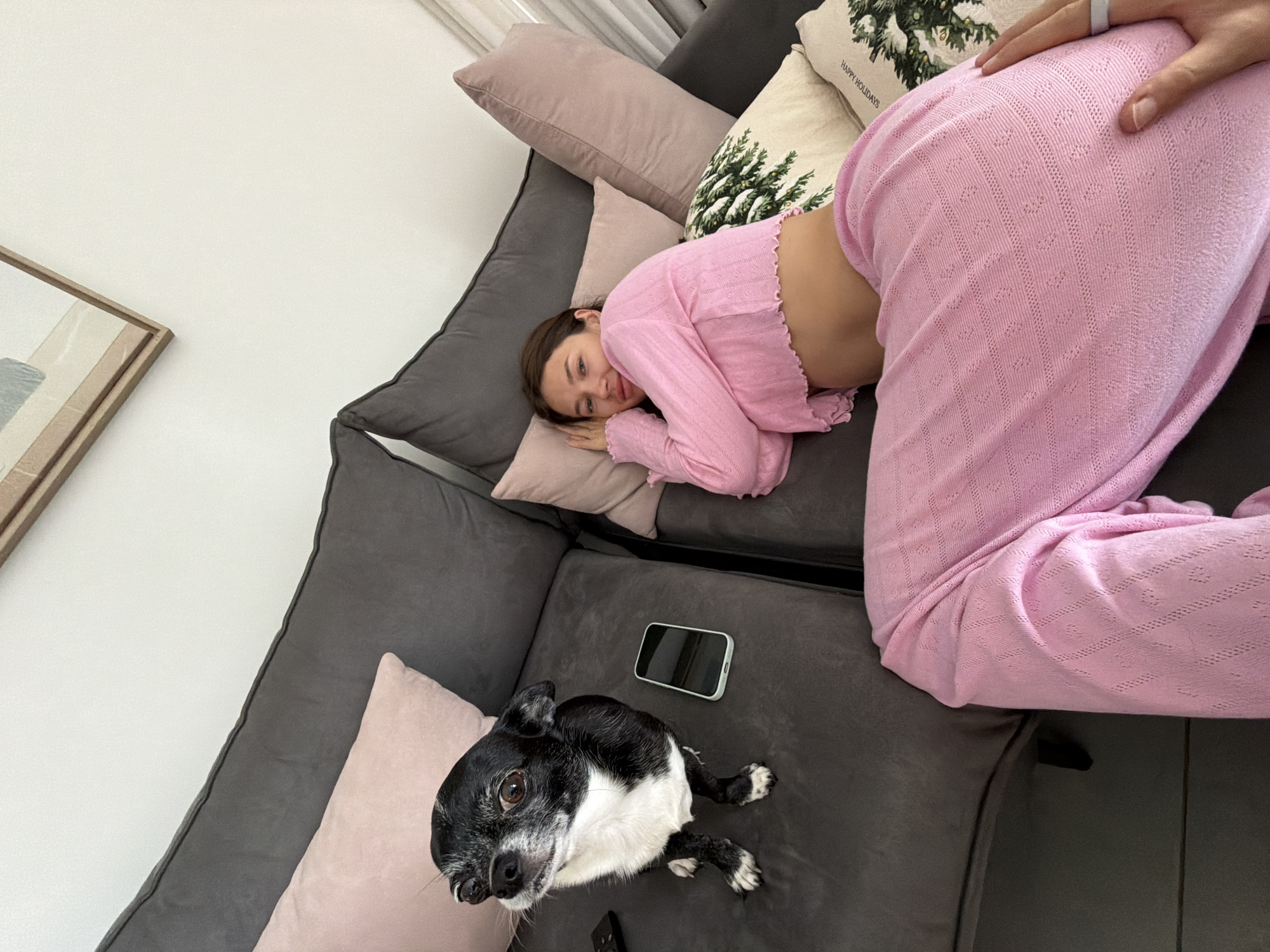 Woman rests with dog on couch in Tel Aviv home
