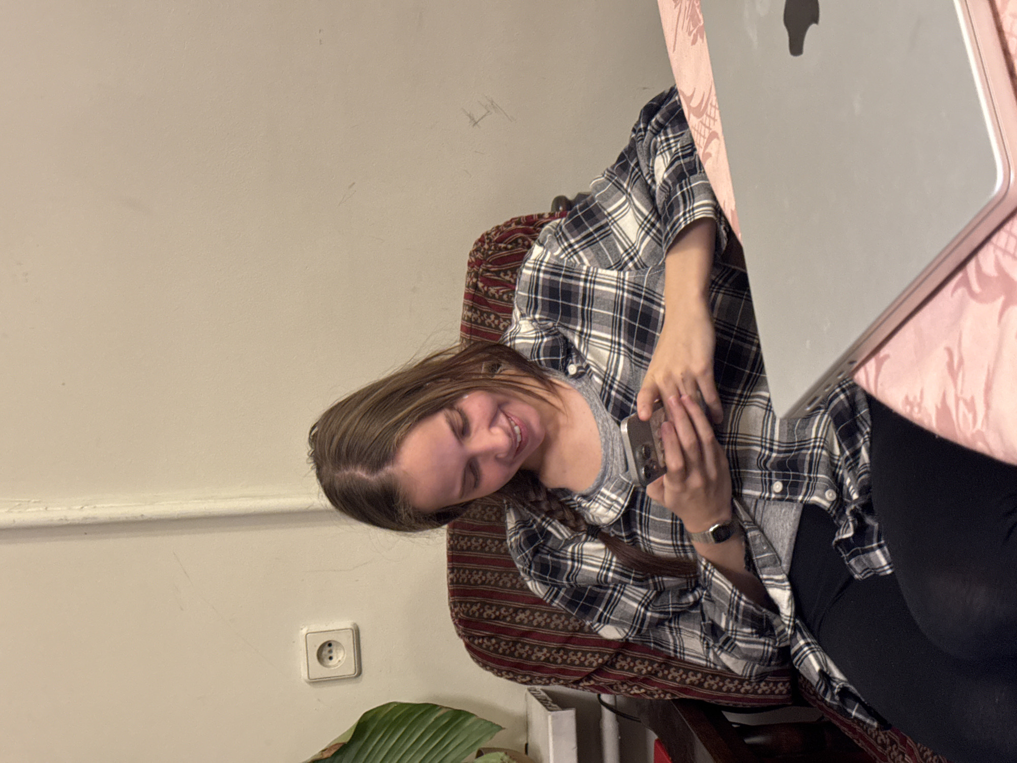 Woman uses smartphone while seated with laptop in Moscow