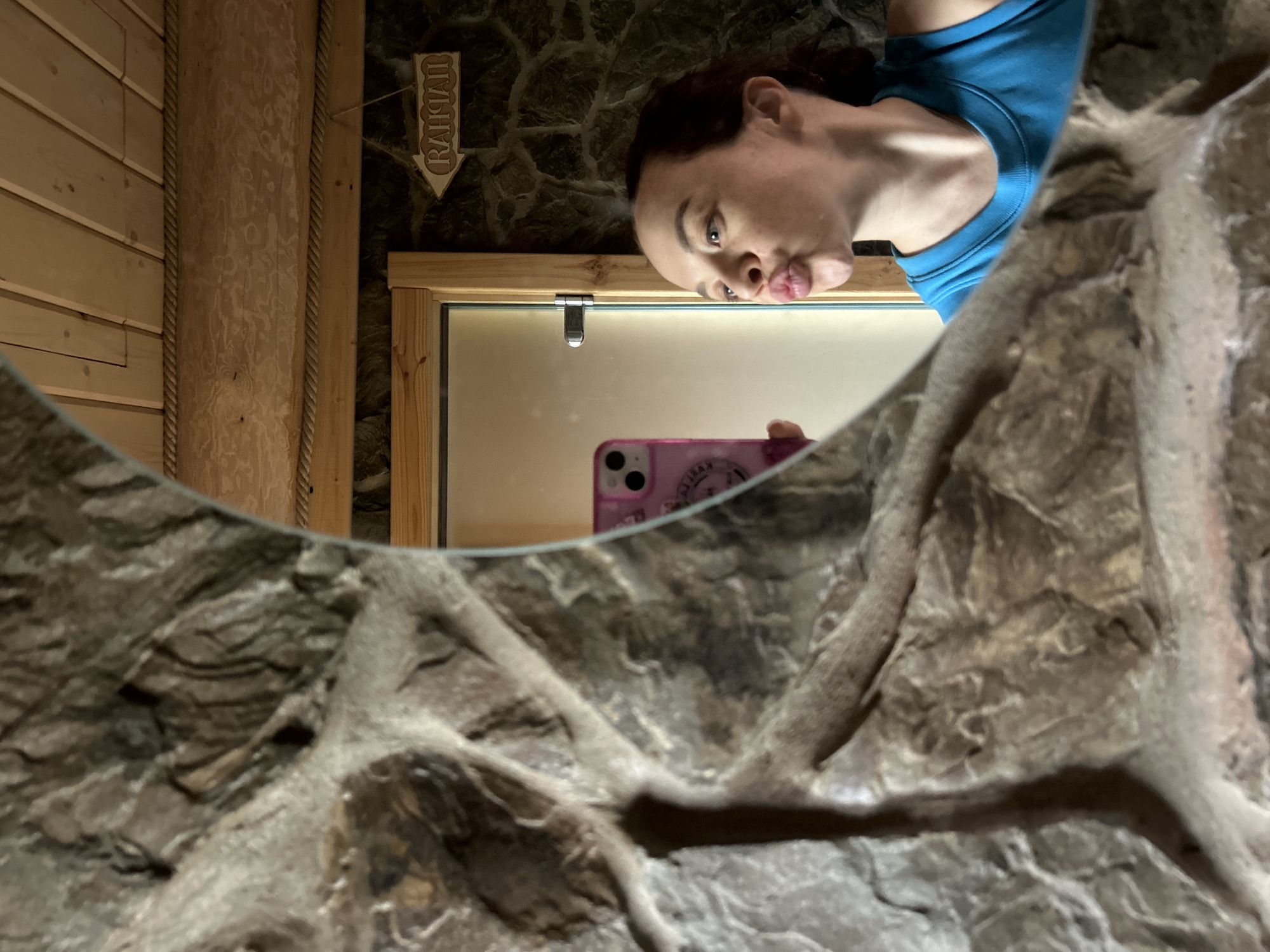 Woman takes selfie in stone-featured restroom in Novyi, Russia