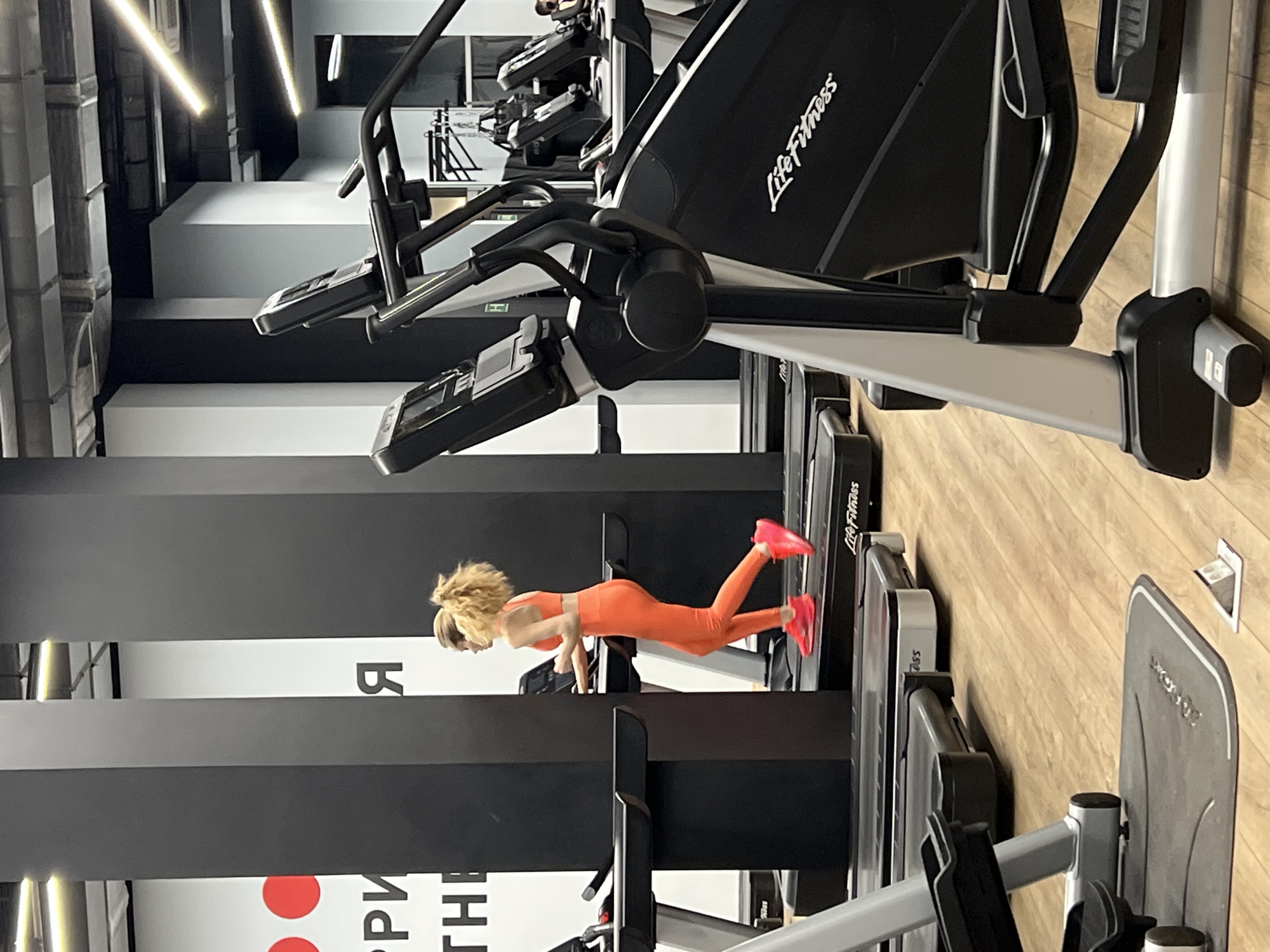 Woman does push-ups on treadmill at Moscow gym