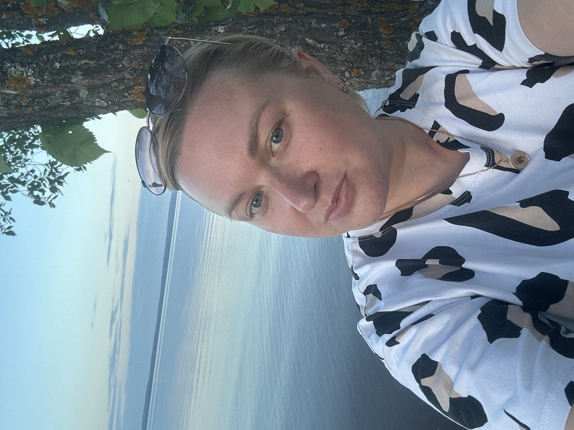Woman takes evening selfies by water in Noviy Russia