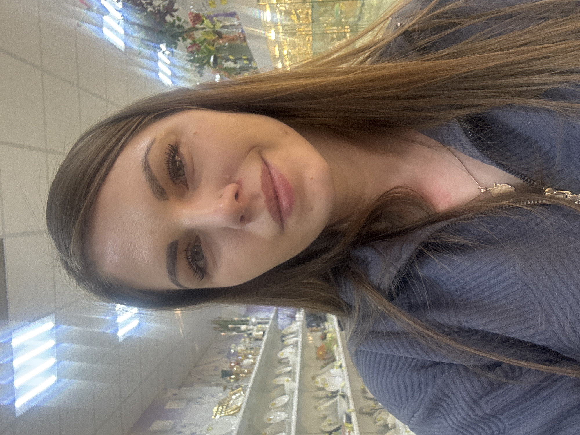 Woman takes selfies with flowers in Klin souvenir shop
