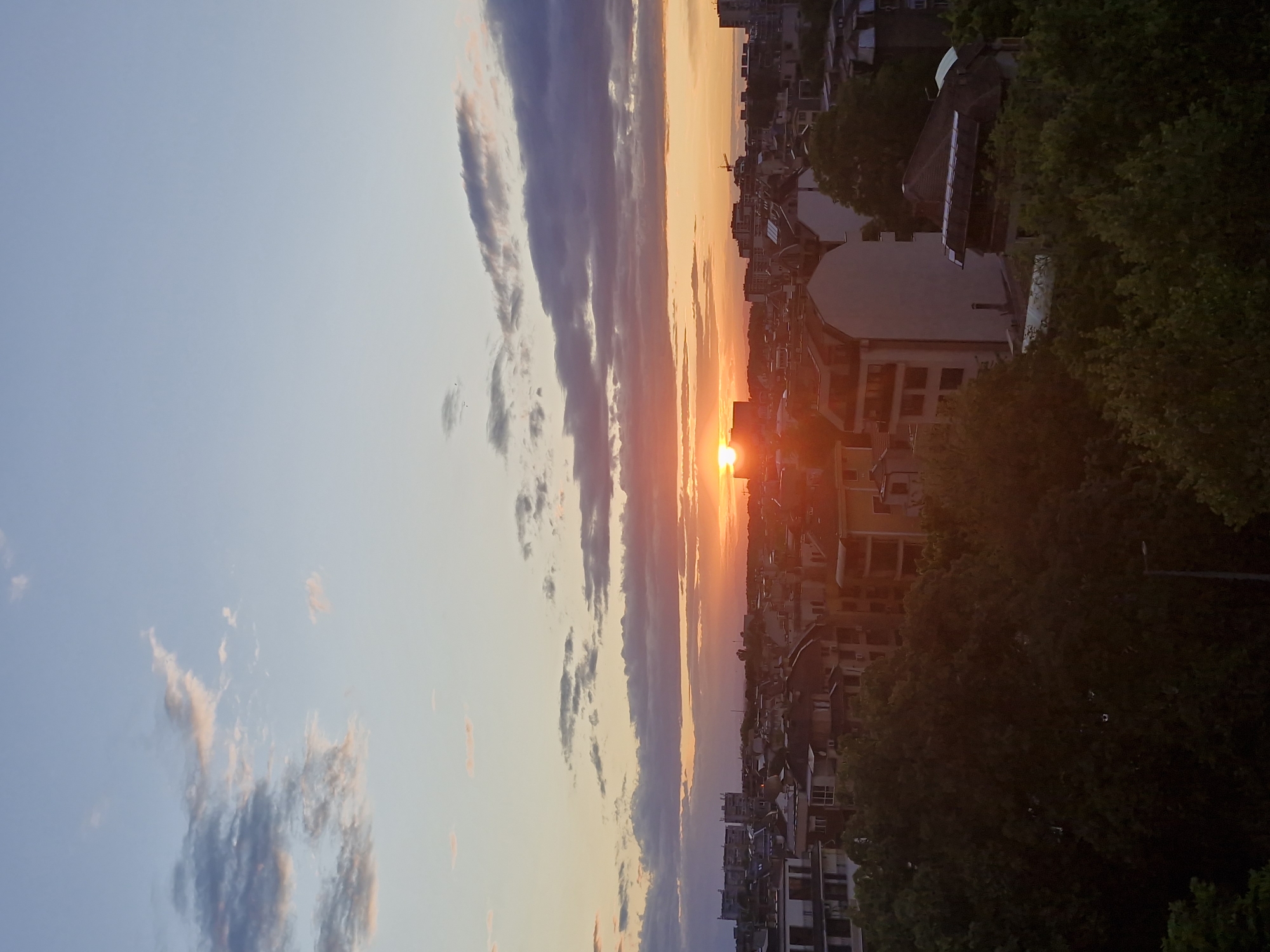 Urban sunset observed with orange sun, gradient sky colors