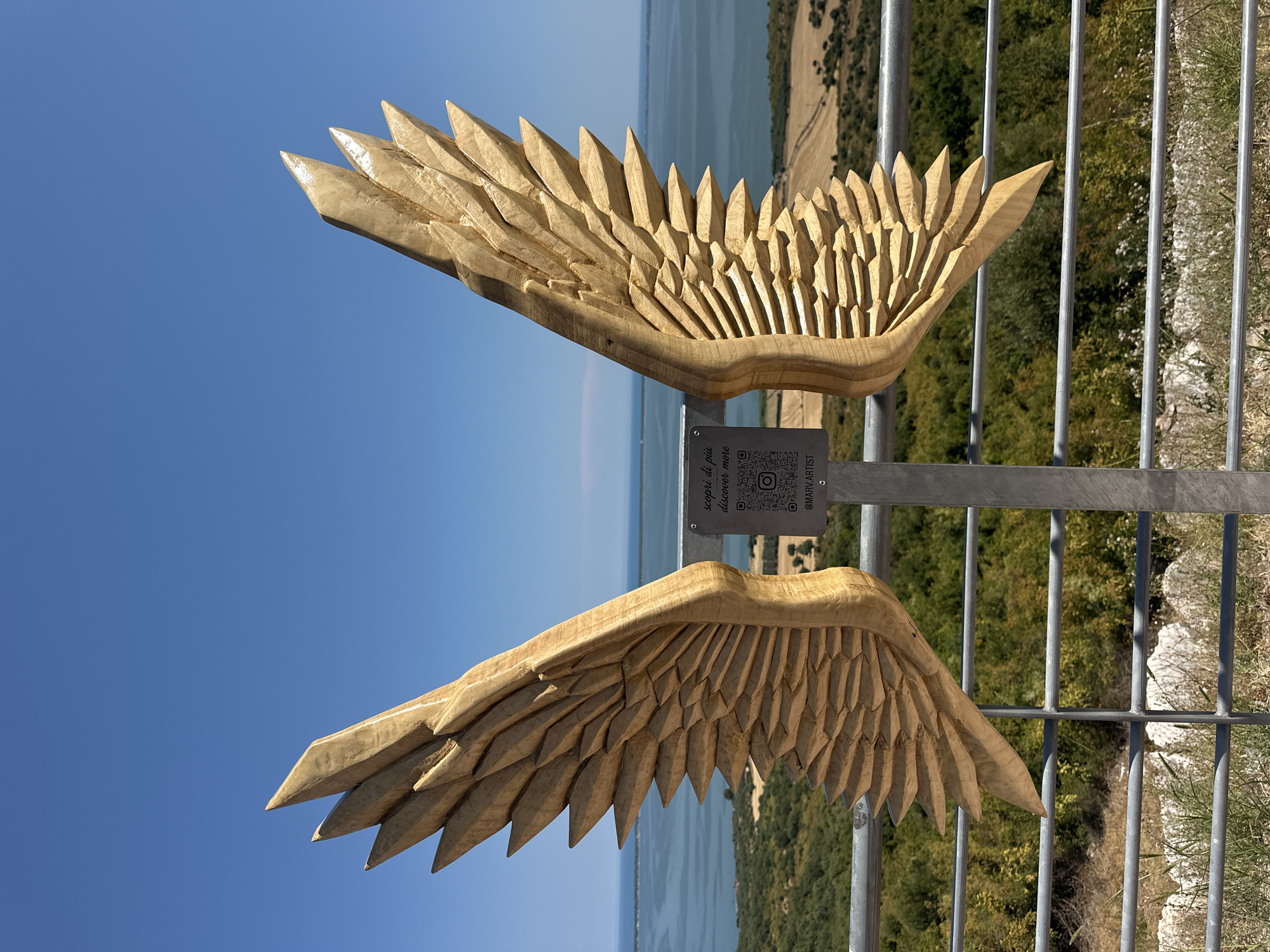 Carved wooden wings at a coastal overlook in Cagnano Varano