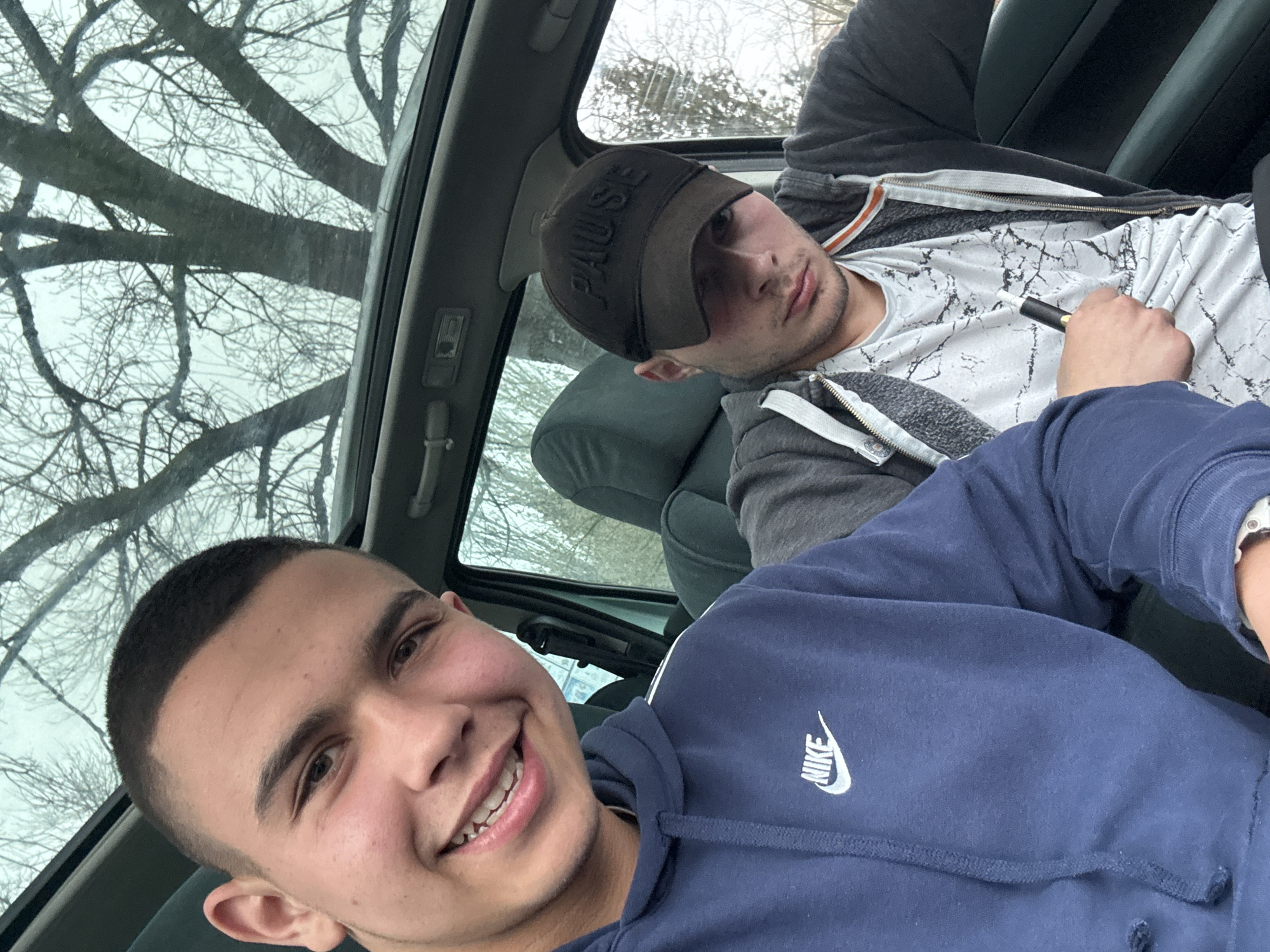 Two men hang out in car in Topoli