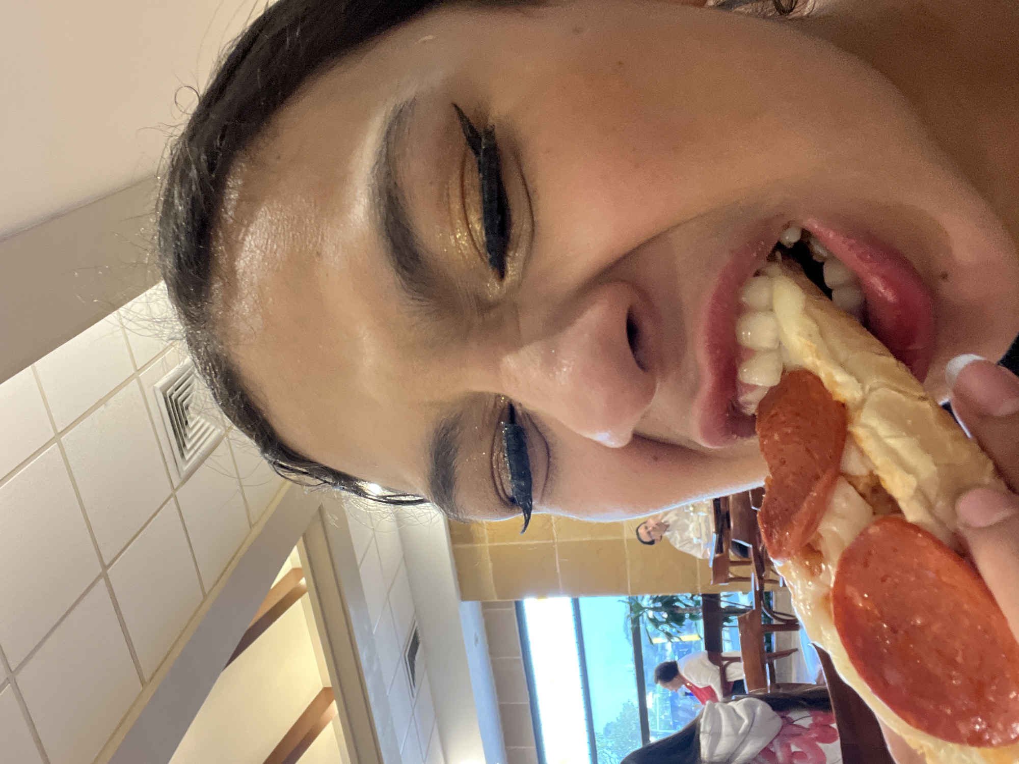 Woman enjoys pizza while enchiladas served at restaurant