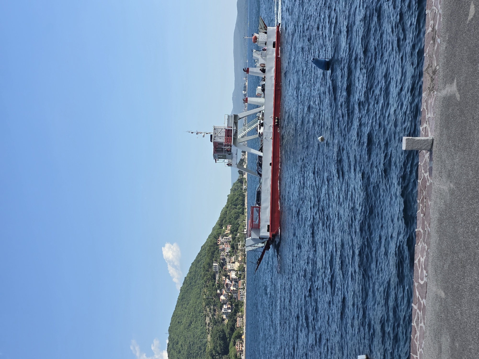 Ferries cross calm waters near Đurići, Montenegro coastline