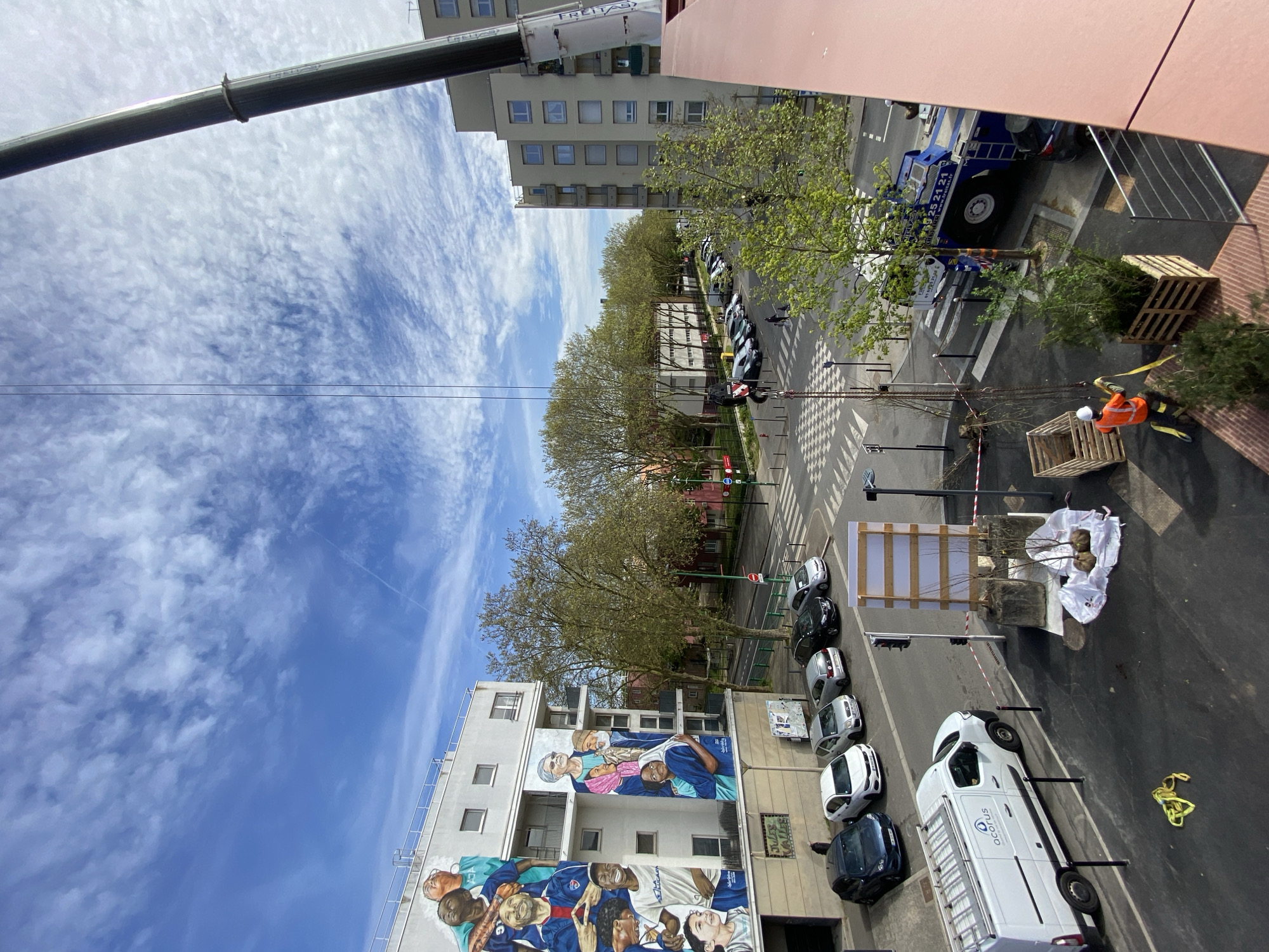 Crane lifts palletized load in Évry-Courcouronnes street operation