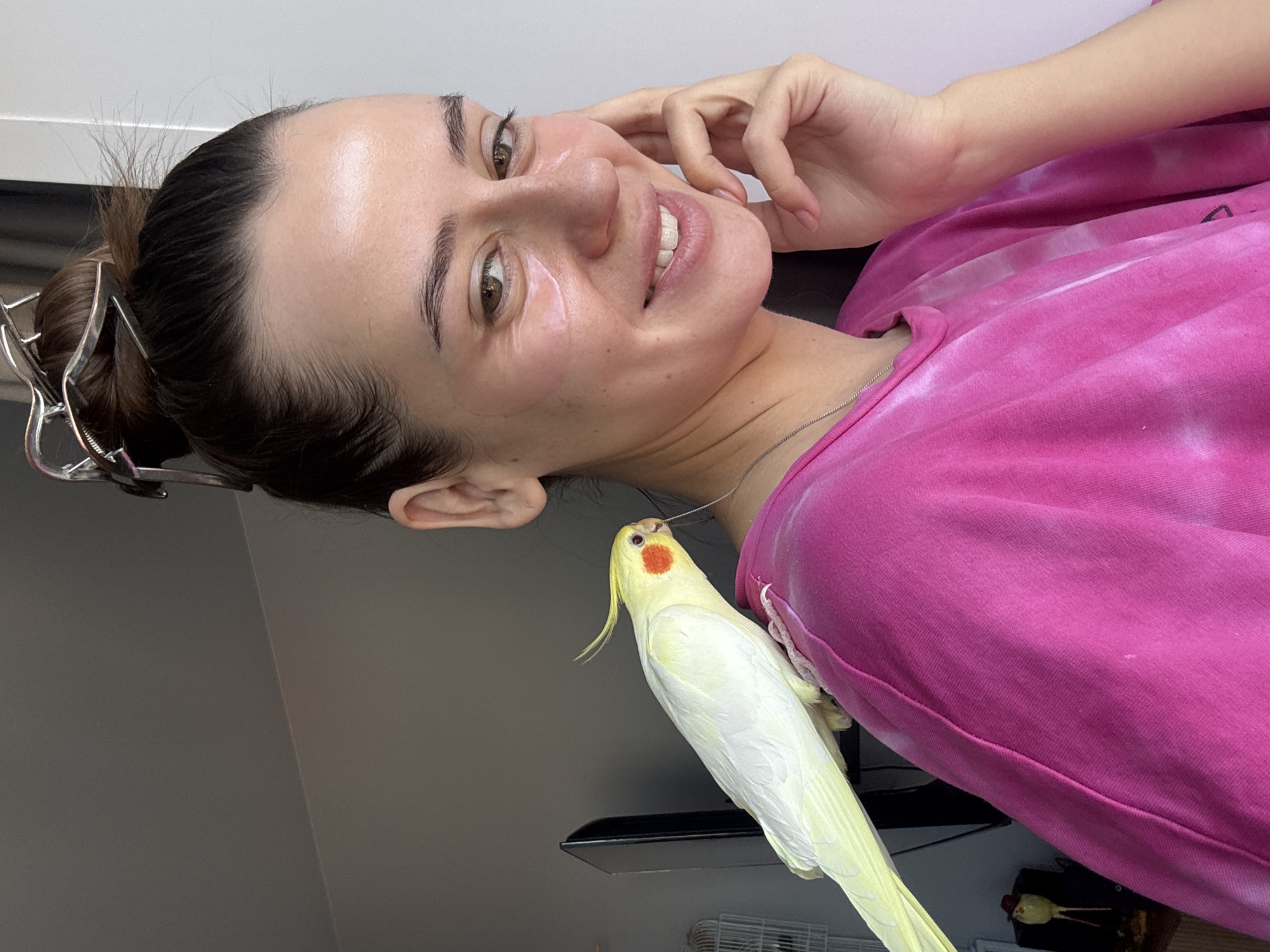 Woman poses with pet cockatiel during breakfast in Krasnoyarsk