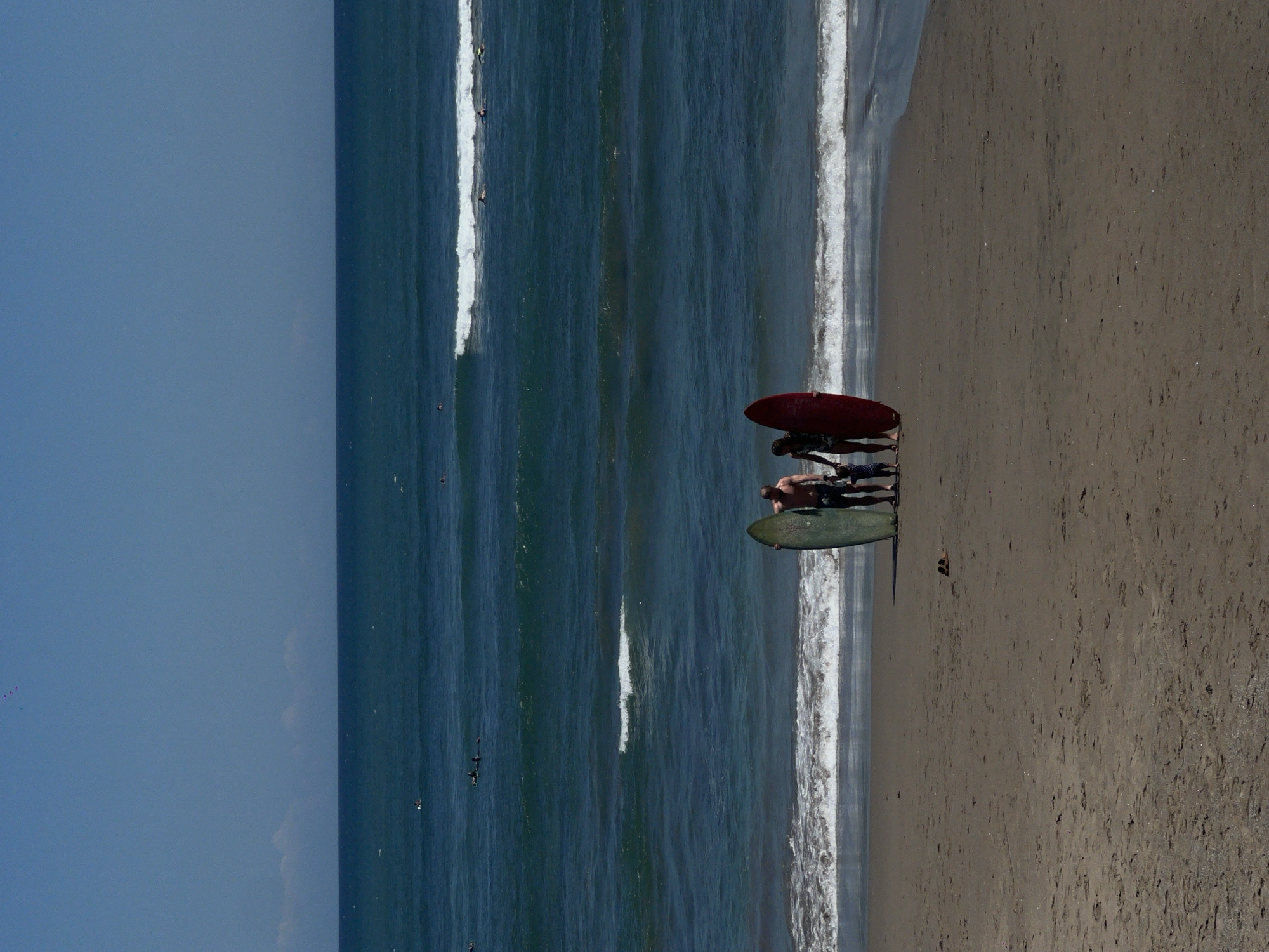 Family with surfboards enjoys morning beach time in North Kuta