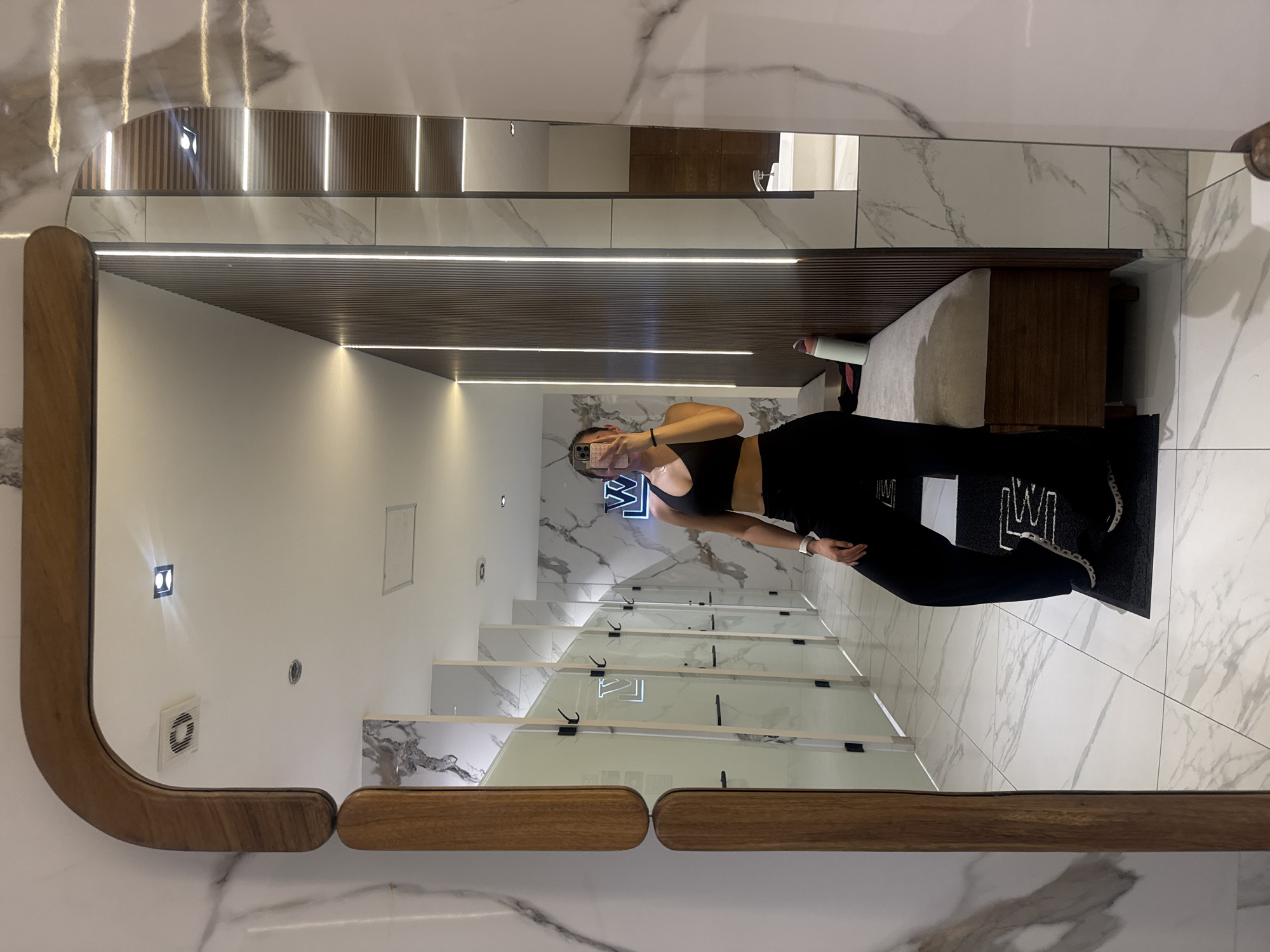 Woman takes mirror selfie in modern room in Puebla