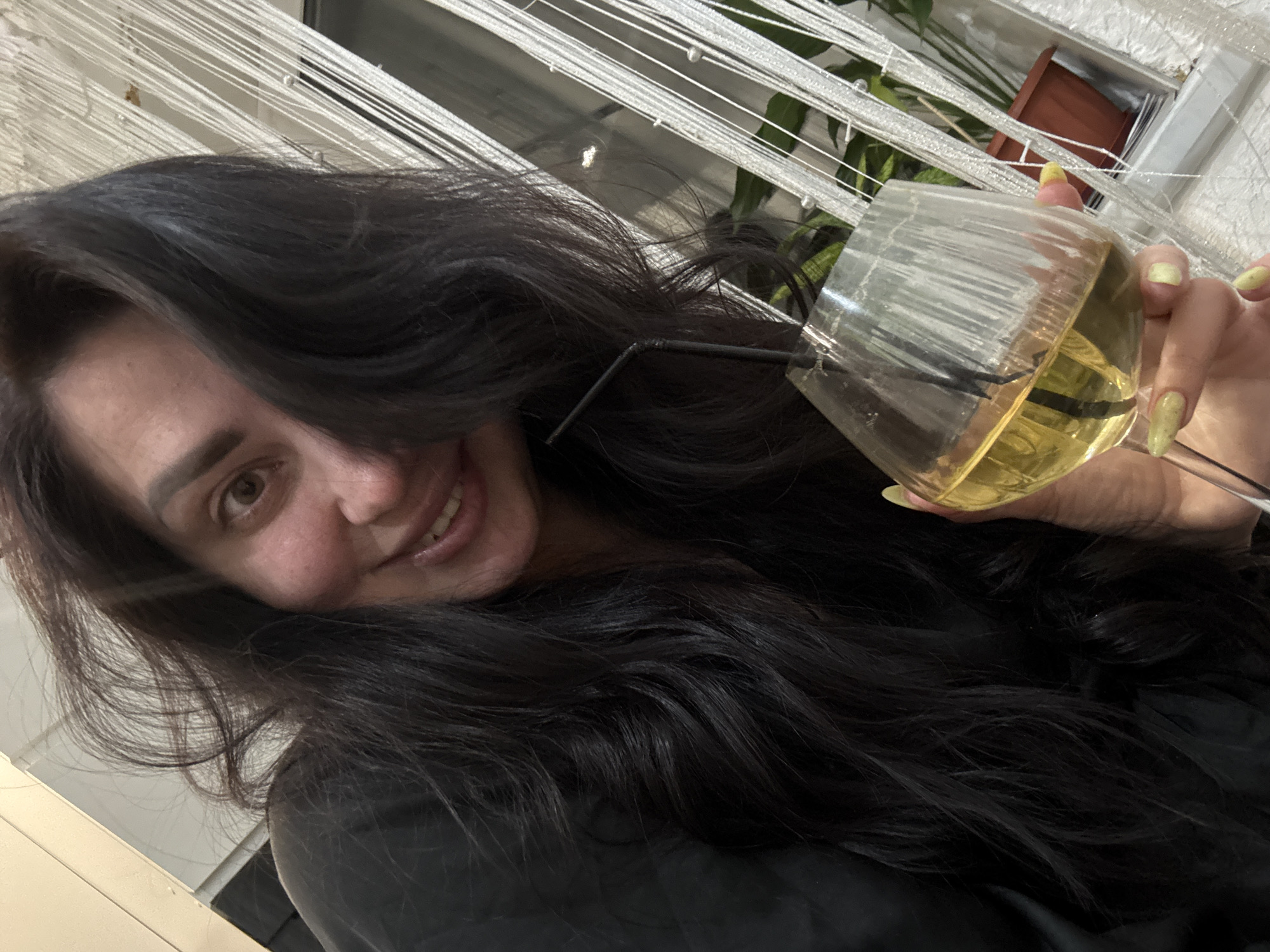 Woman enjoys yellow drink at home with tulips