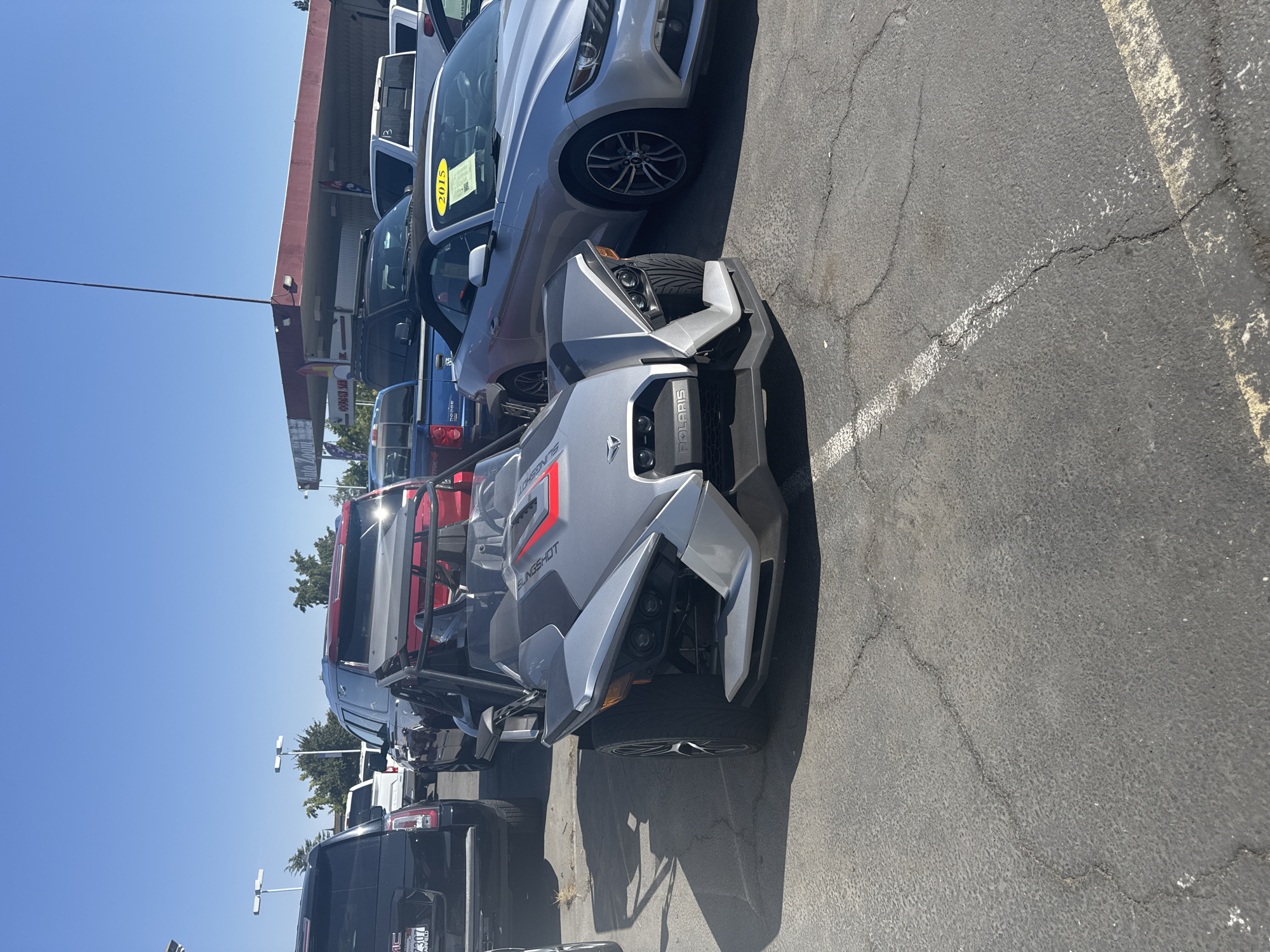 Polaris Slingshot parked alongside a Mustang convertible in Rancho Cordova