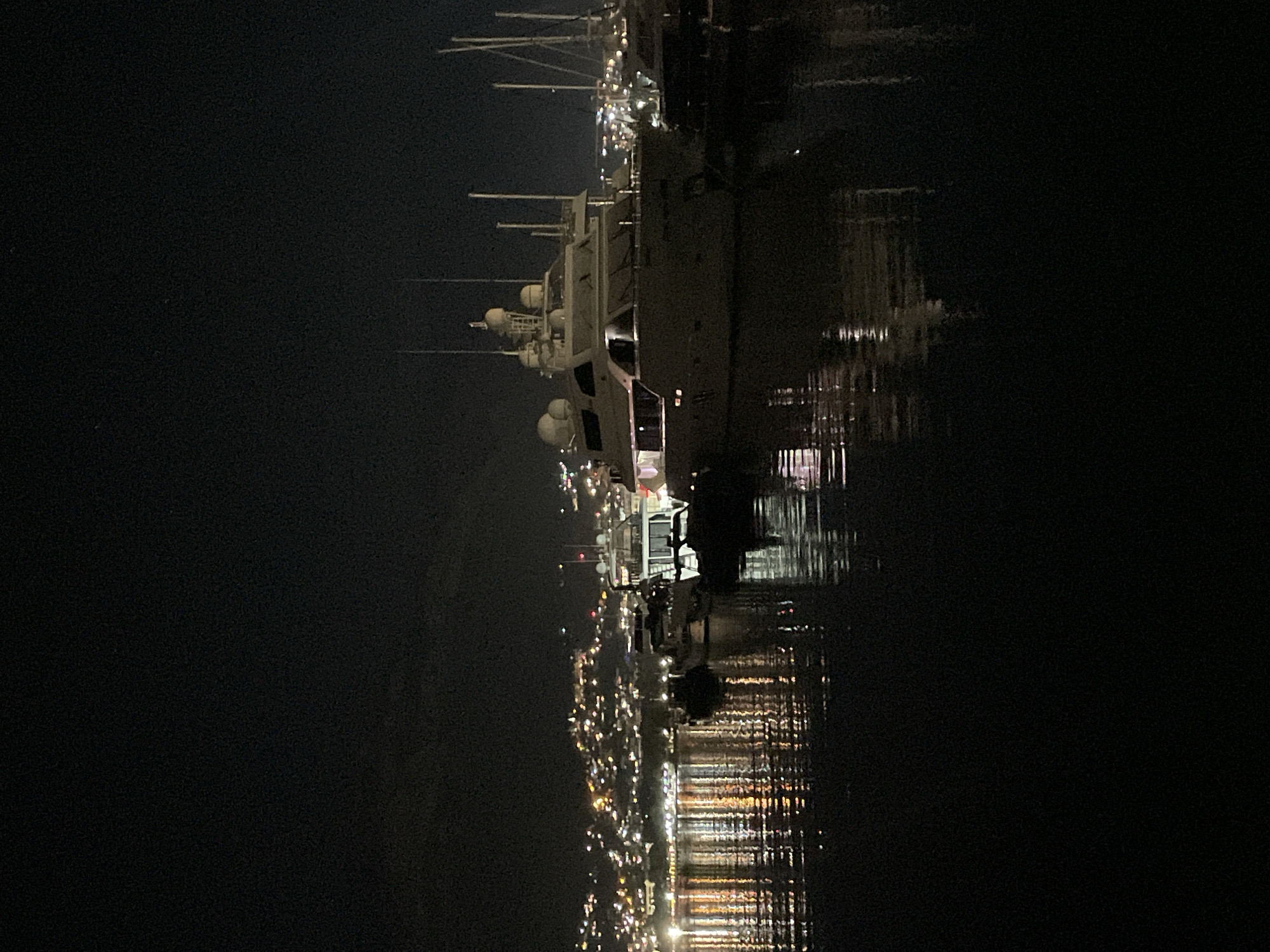 Bar marina at night, boats moored under a crescent moon