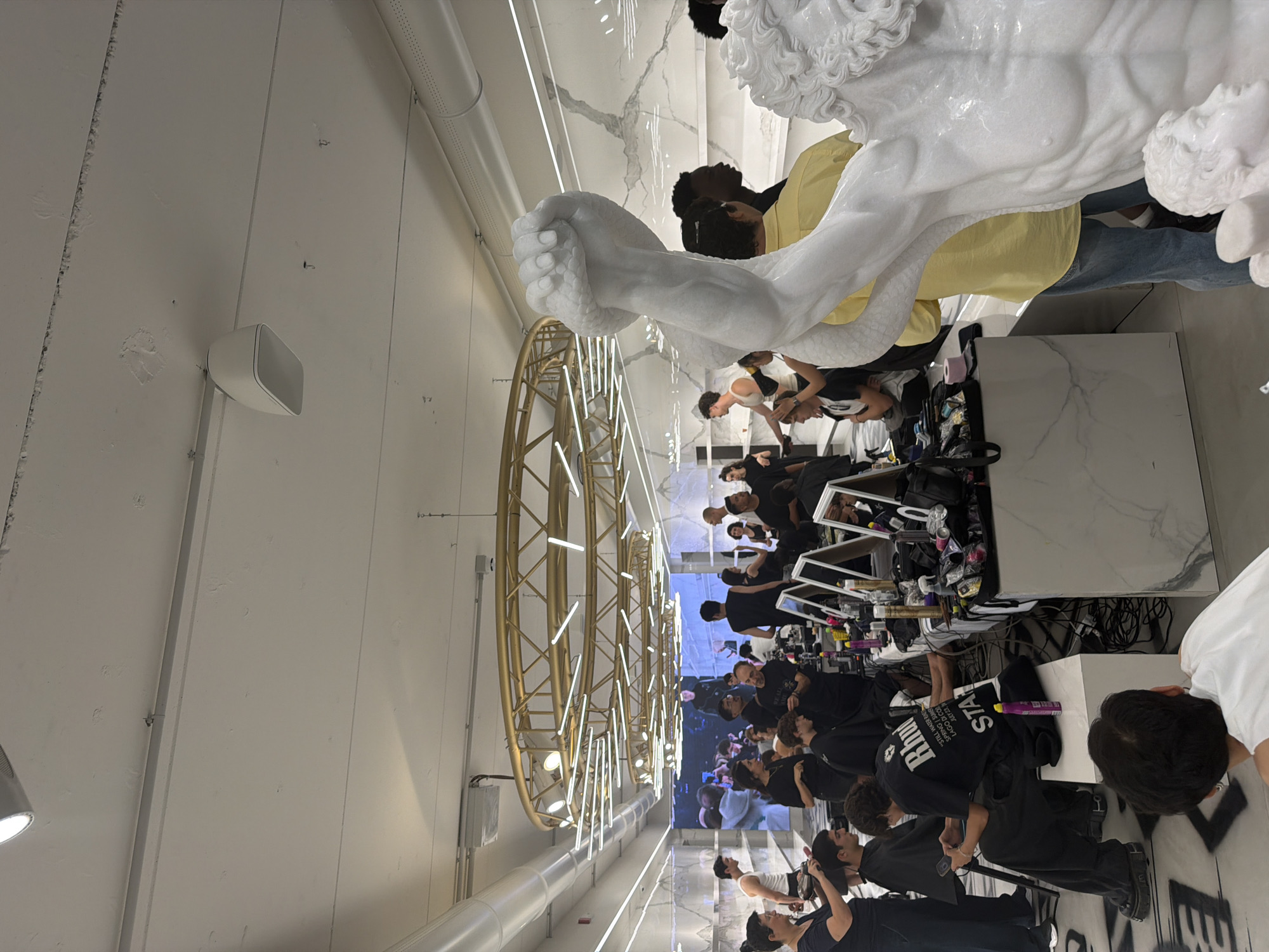 Milan fashion event prep: casting boards, makeup stations, and marble sculpture