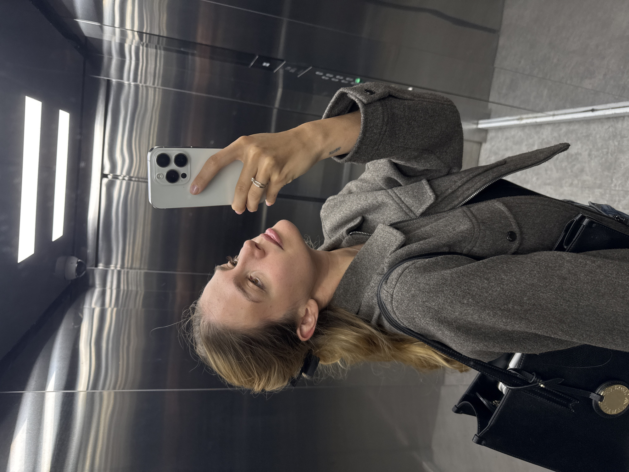 Woman Takes Mirror Selfie in Elevator
