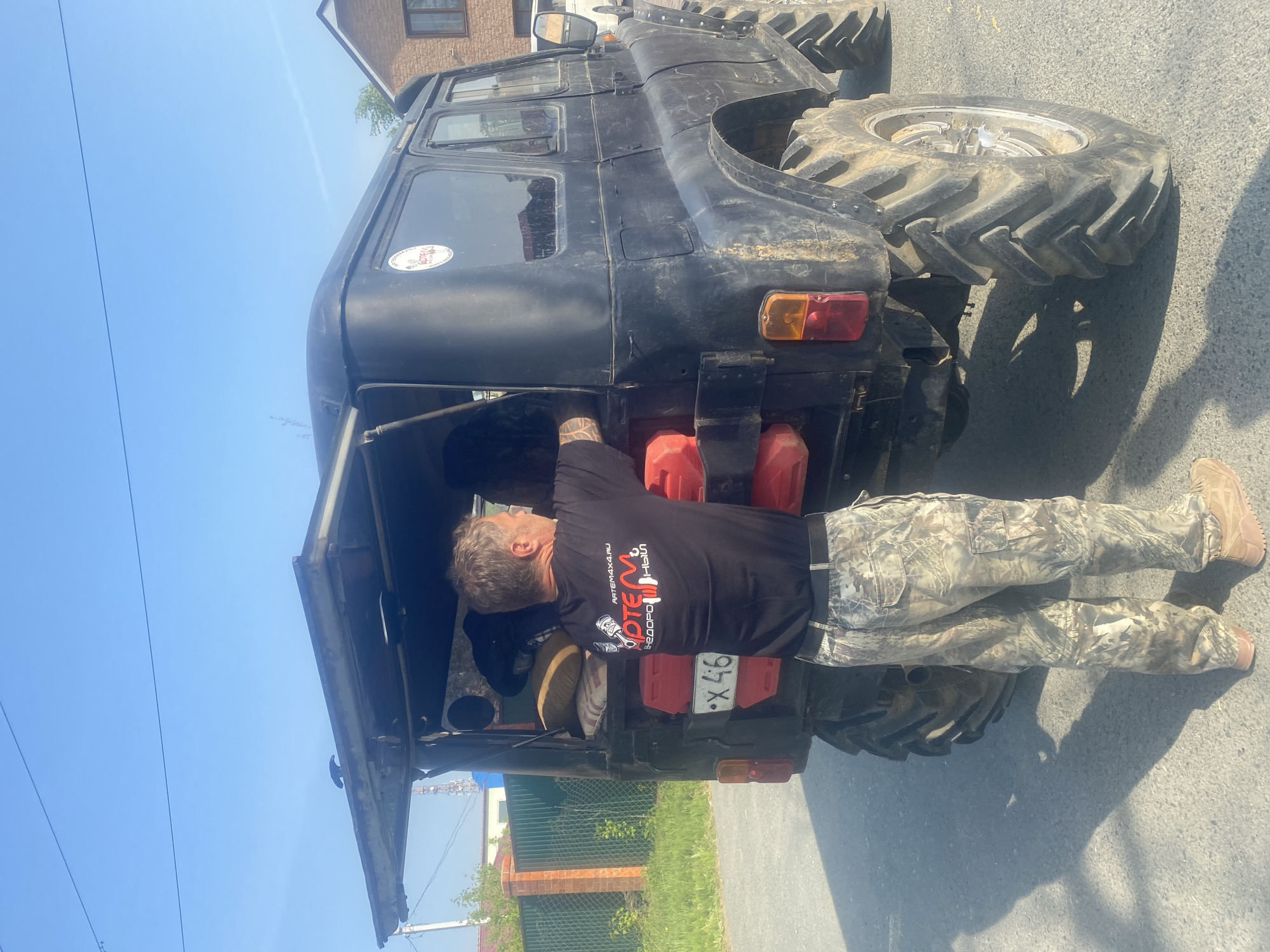 Man stands behind open SUV on residential street in Artyom