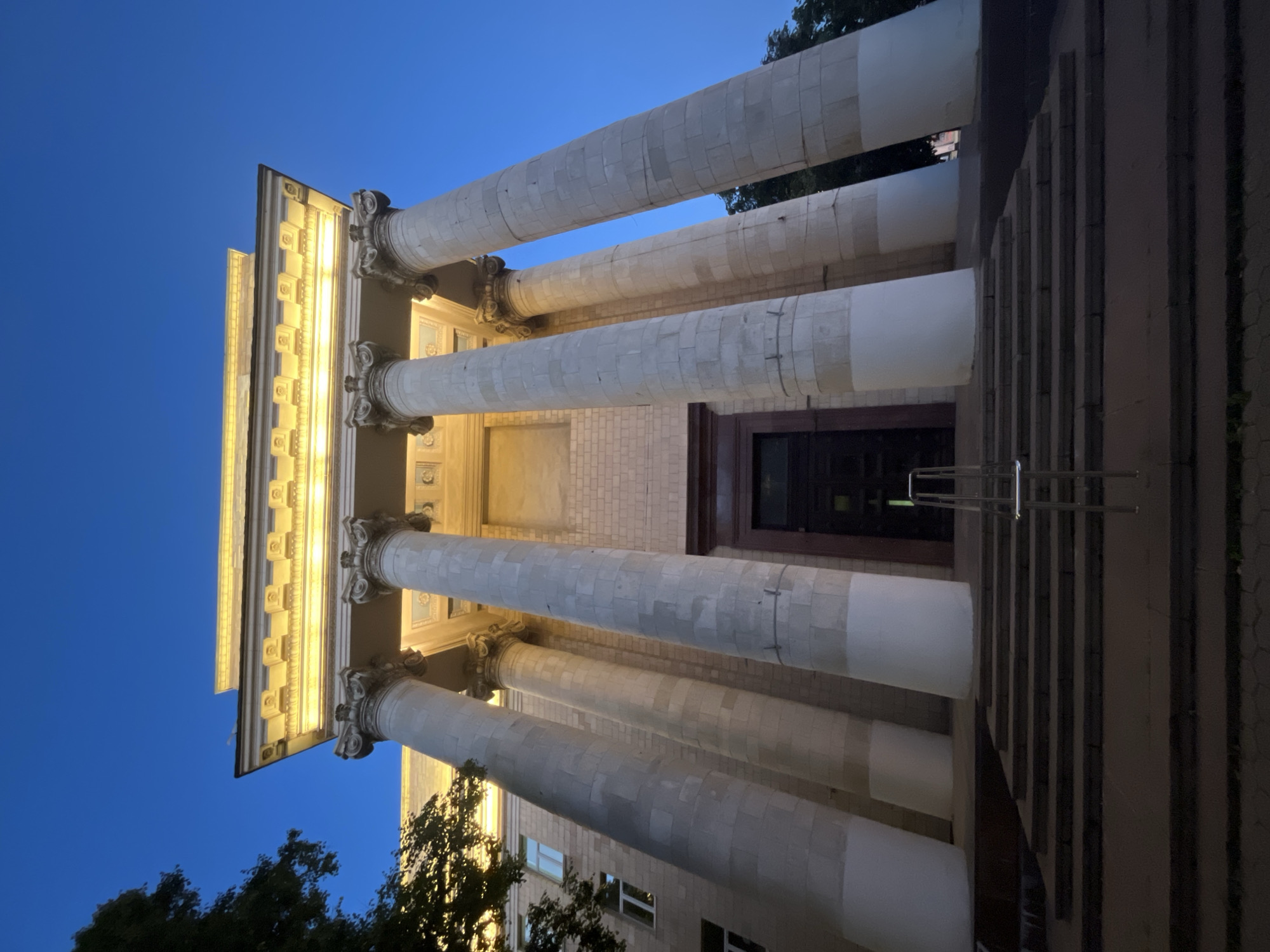 Classical architecture, vintage truck, and memorial bust at a heritage site