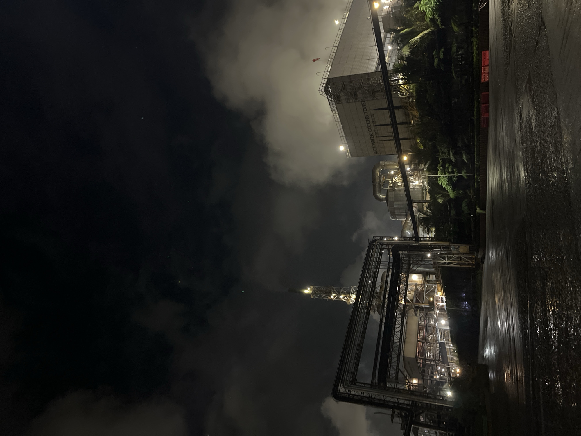 Industrial complex with cooling tower observed at night in Indonesia