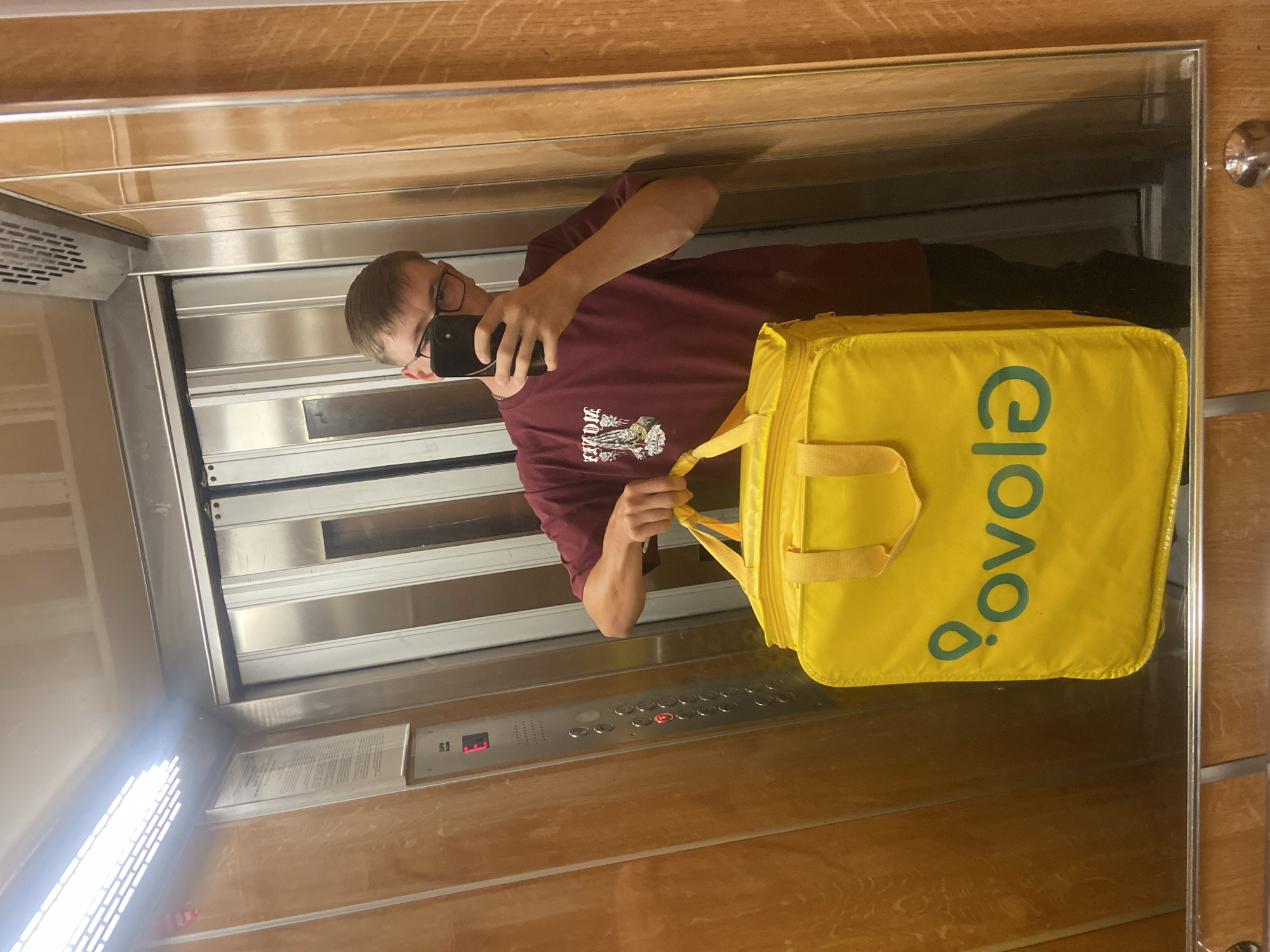 Elevator mirror selfie with a food delivery bag in Bolesławiec